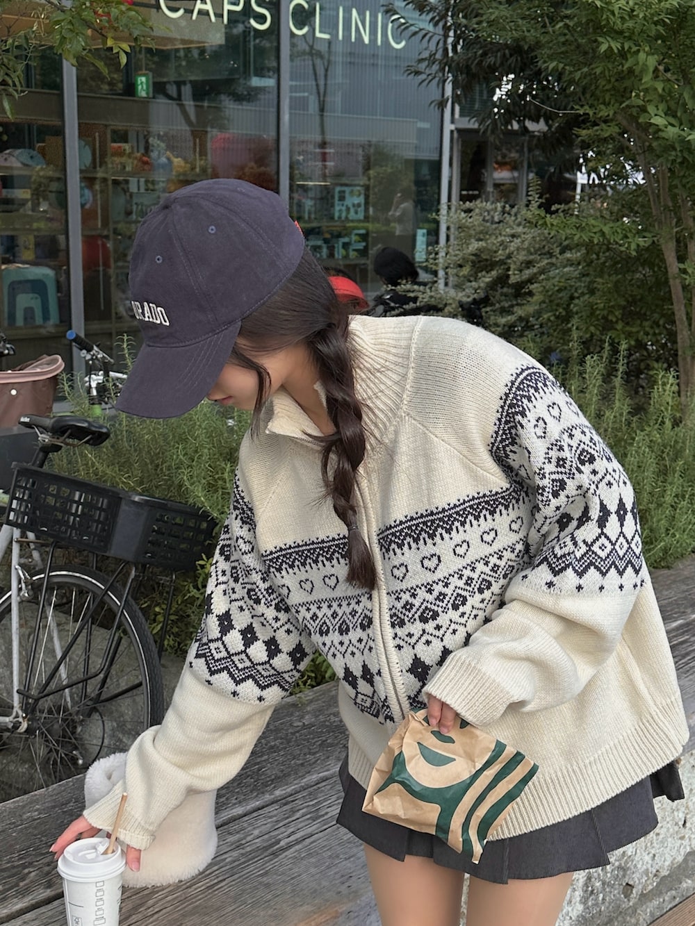 ホワイト系のニット/セーター、グレー系のスカート、ブラック系のブーツを着用したレディースの冬コーディネートの2枚目の写真