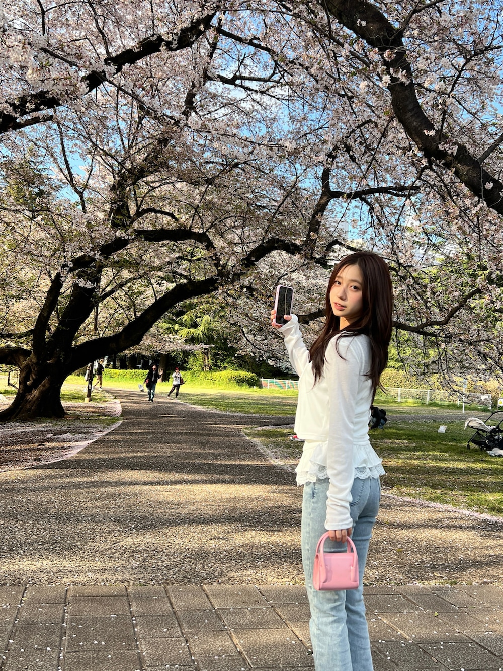 ホワイト系のトップスを着用したレディースの春コーディネートの2枚目の写真