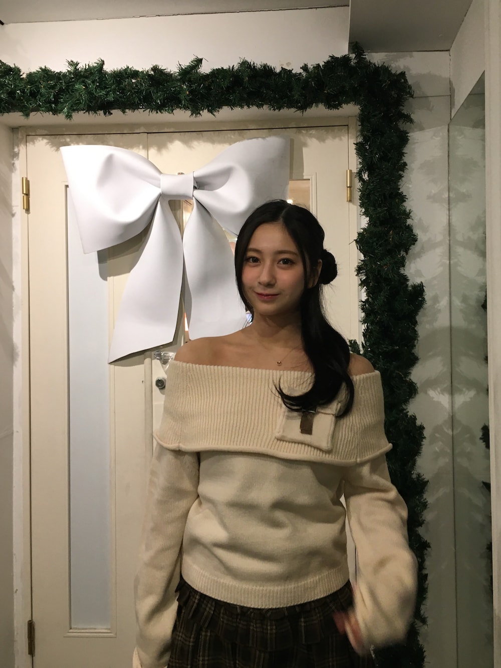 ブラウン系のブーツ、ブラウン系のスカート、ホワイト系のニット/セーターを着用したレディースの冬コーディネートの4枚目の写真