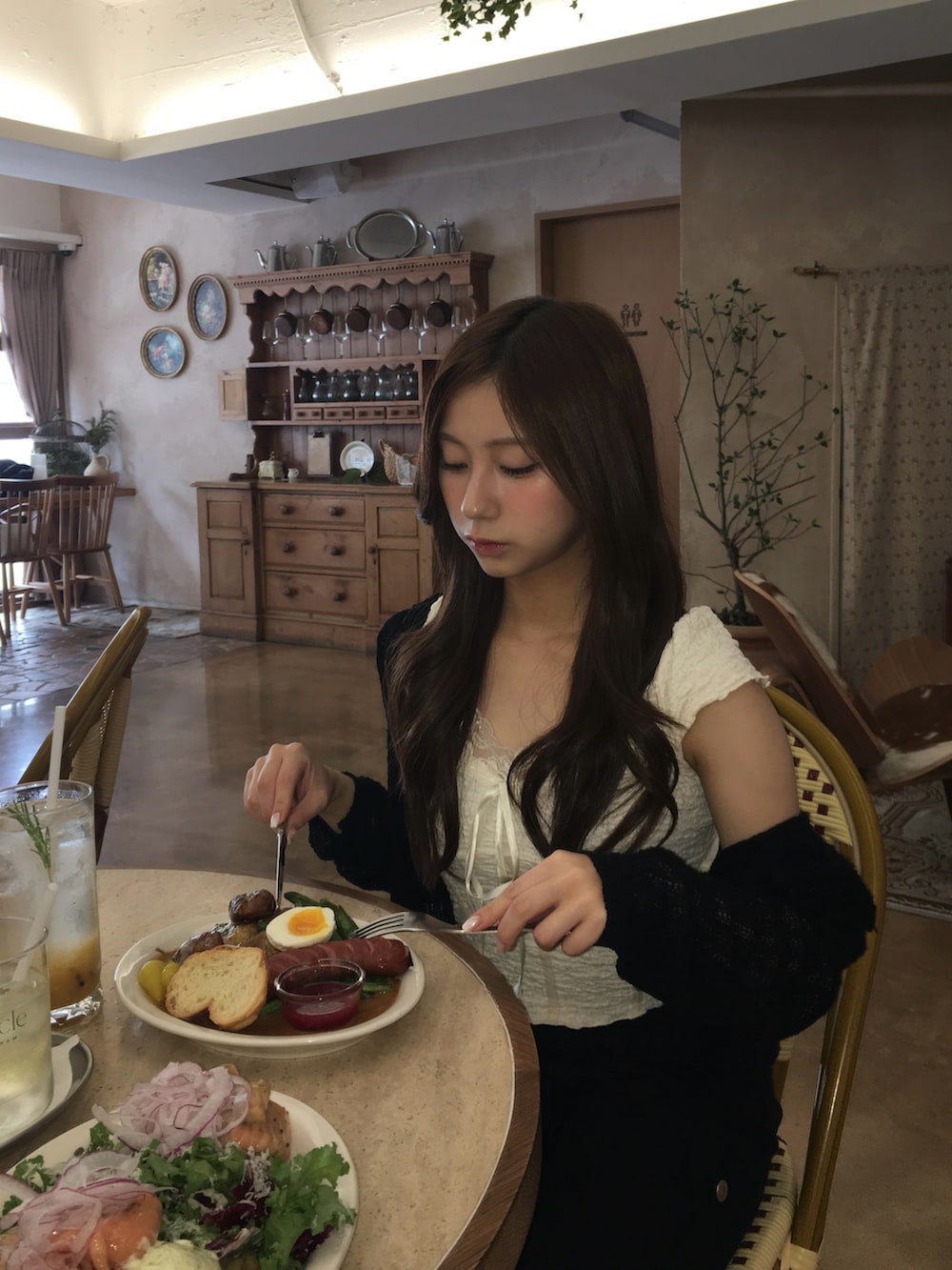 ホワイト系のトップス、ブラック系のパンツ、ホワイト系のトップスを着用したレディースの夏コーディネートの2枚目の写真