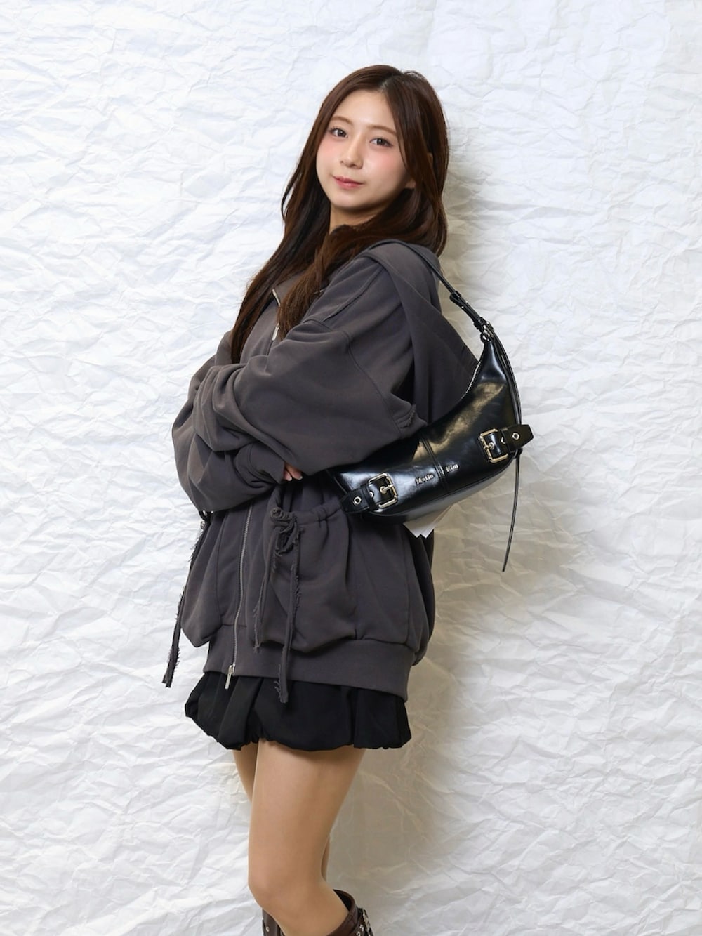 グレー系のジャケット/アウター、ブラウン系のブーツ、ブラック系のスカートを着用したレディースの春コーディネートの2枚目の写真