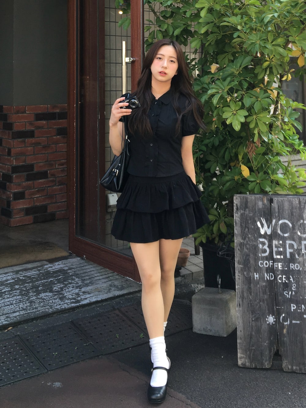 ブラック系のトップス、ブラック系のスカートを着用したレディースの夏コーディネートの2枚目の写真