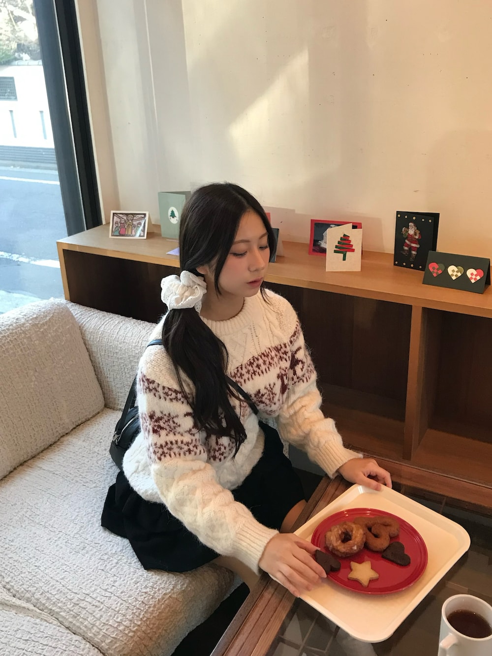 ホワイト系のニット/セーター、ブラック系のスカート、ブラック系のブーツを着用したレディースの冬コーディネートの3枚目の写真