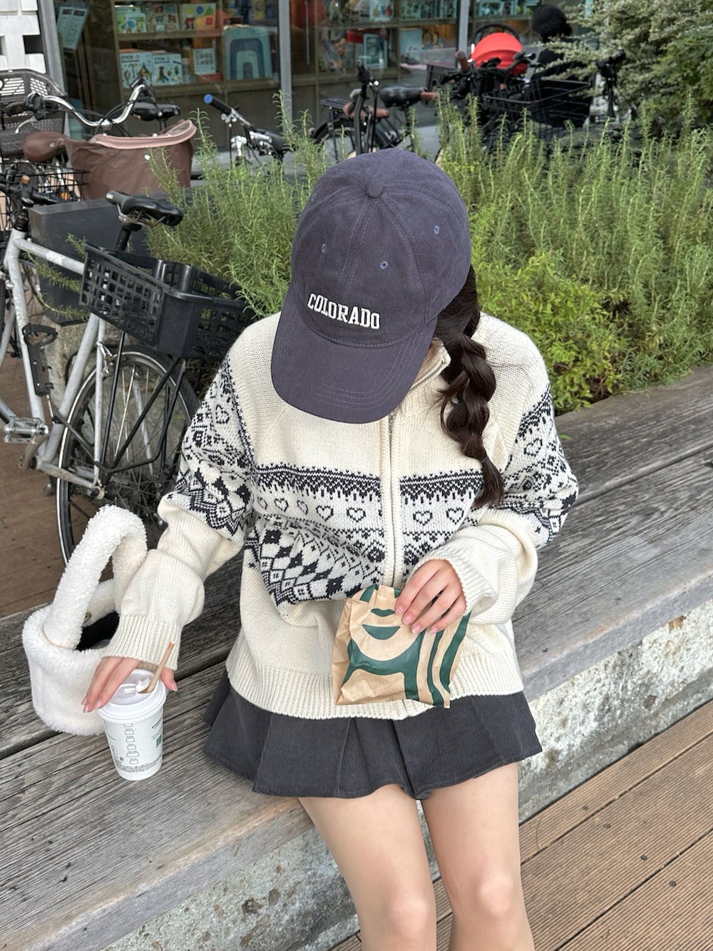 ホワイト系のニット/セーター、グレー系のスカート、ブラック系のブーツを着用したレディースの冬コーディネートの3枚目の写真