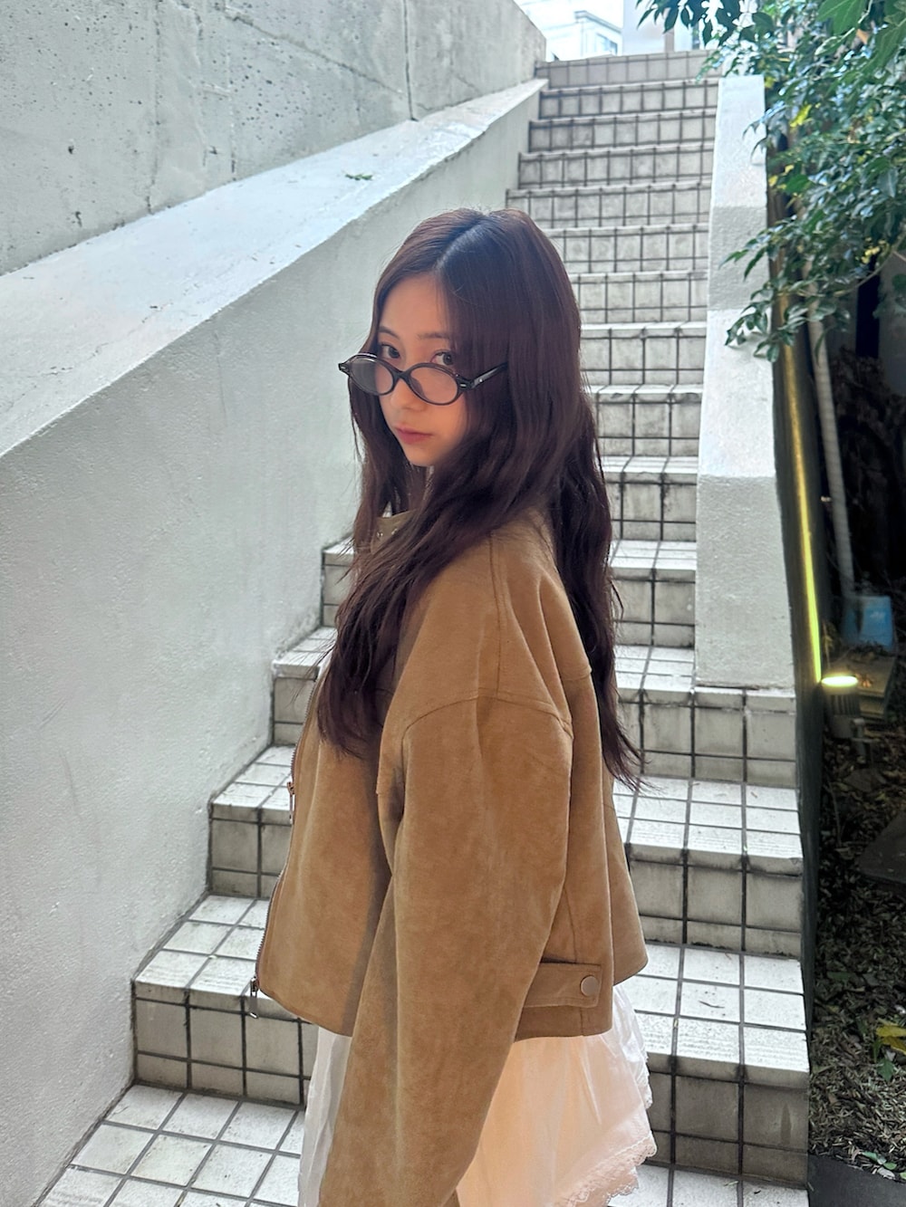 ホワイト系のスカート、ホワイト系のキャミソール、ベージュ系のブルゾンを着用したレディースの秋コーディネートの2枚目の写真