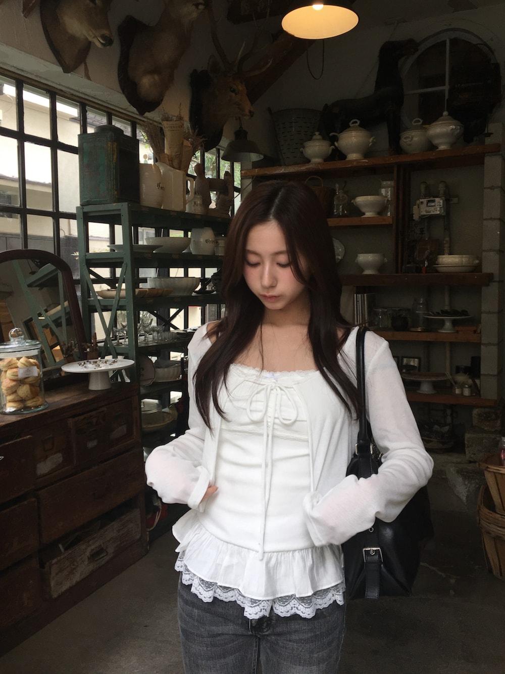 グレー系のデニムパンツ、ホワイト系のトップスを着用したレディースの春コーディネートの2枚目の写真