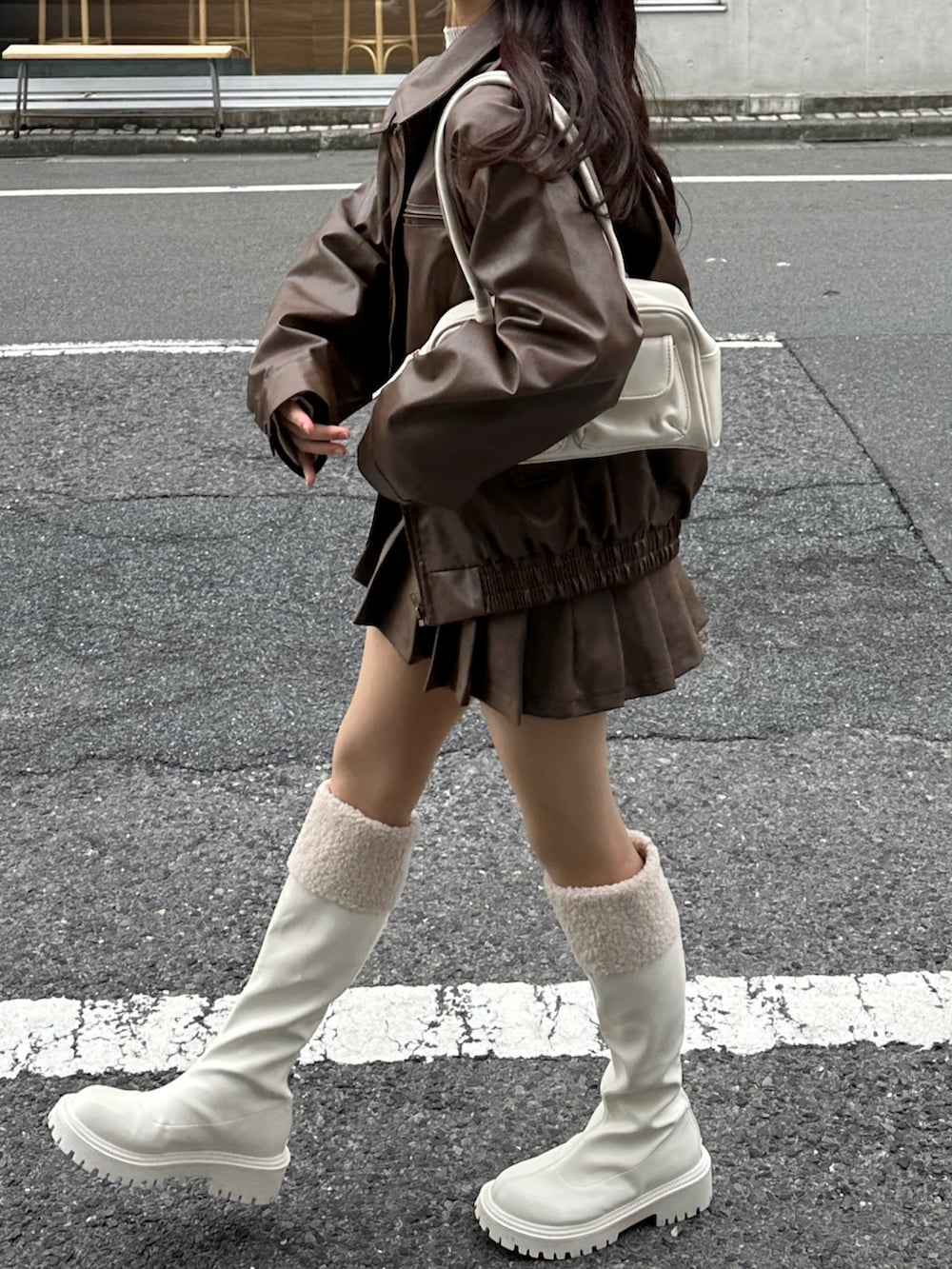 ブラウン系のブルゾン、ブラウン系のスカートを着用したレディースの春コーディネートの3枚目の写真