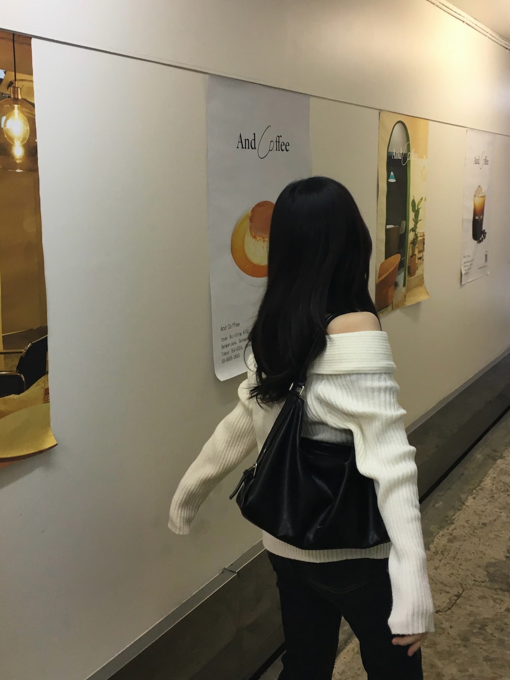 ブラック系のバッグ、ホワイト系のニット/セーターを着用したレディースの冬コーディネートの2枚目の写真