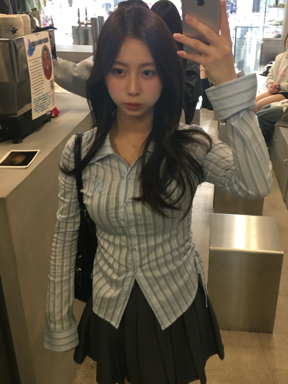 グレー系のスカート、ブルー系のシャツ/ブラウスを着用したレディースの春コーディネートの2枚目の写真