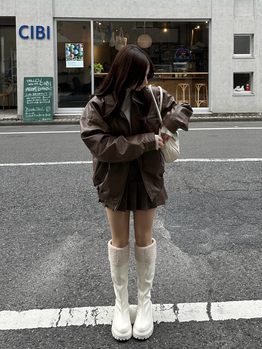 ブラウン系のブルゾン、ブラウン系のスカートを着用したレディースの春コーディネートの2枚目の写真