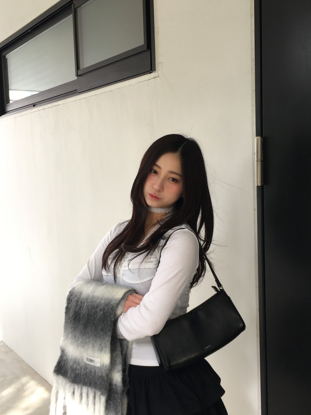 ブラウン系のブーツ、ブラック系のスカート、ホワイト系のTシャツ/カットソーを着用したレディースの冬コーディネートの3枚目の写真