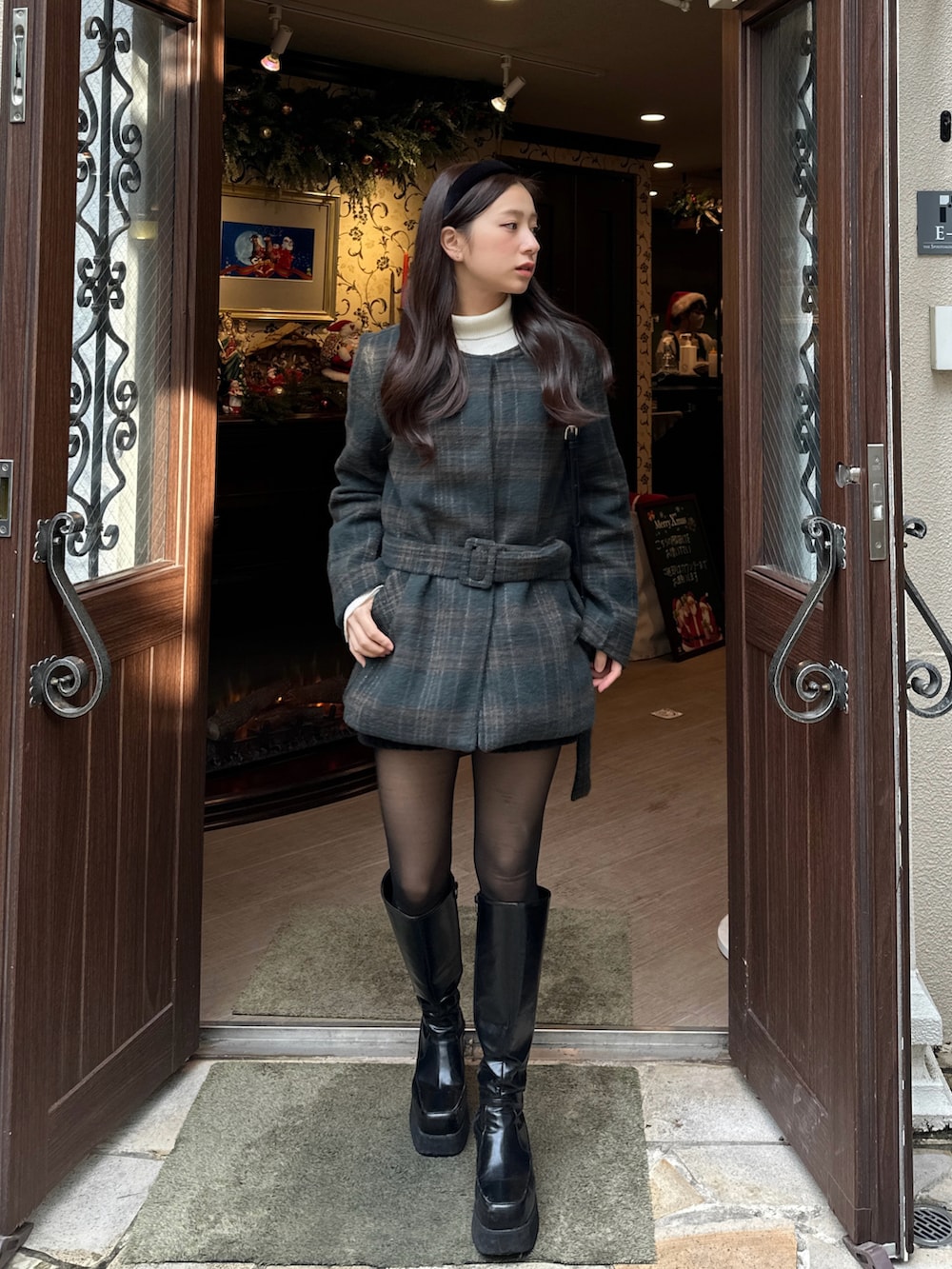 ブラック系のブーツ、グリーン系のワンピースを着用したレディースの冬コーディネートの3枚目の写真