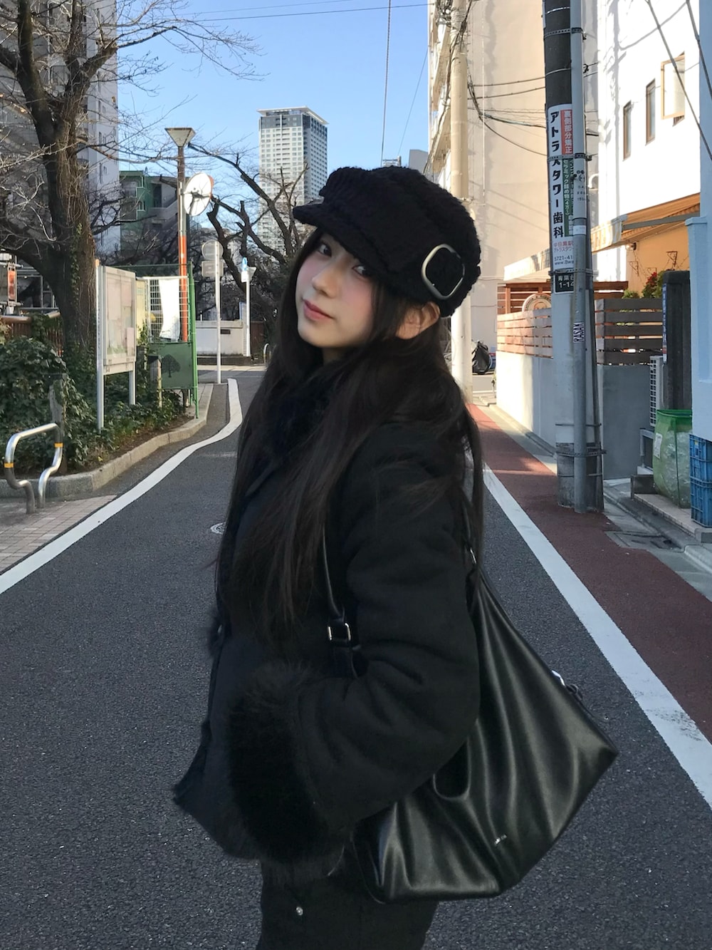 ブラック系のジャケット/アウター、ブラック系の帽子を着用したレディースの冬コーディネートの2枚目の写真