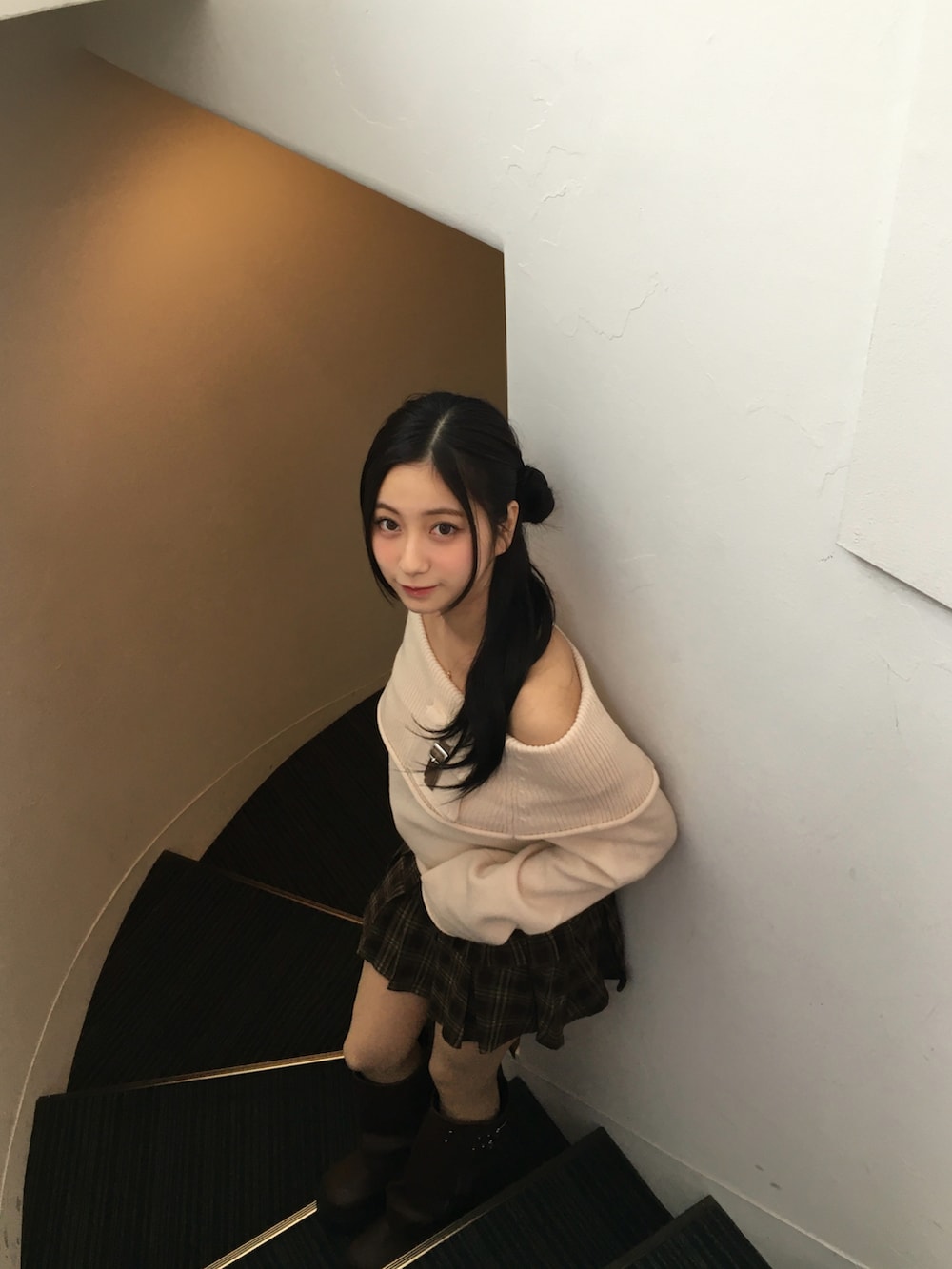 ブラウン系のブーツ、ブラウン系のスカート、ホワイト系のニット/セーターを着用したレディースの冬コーディネートの2枚目の写真