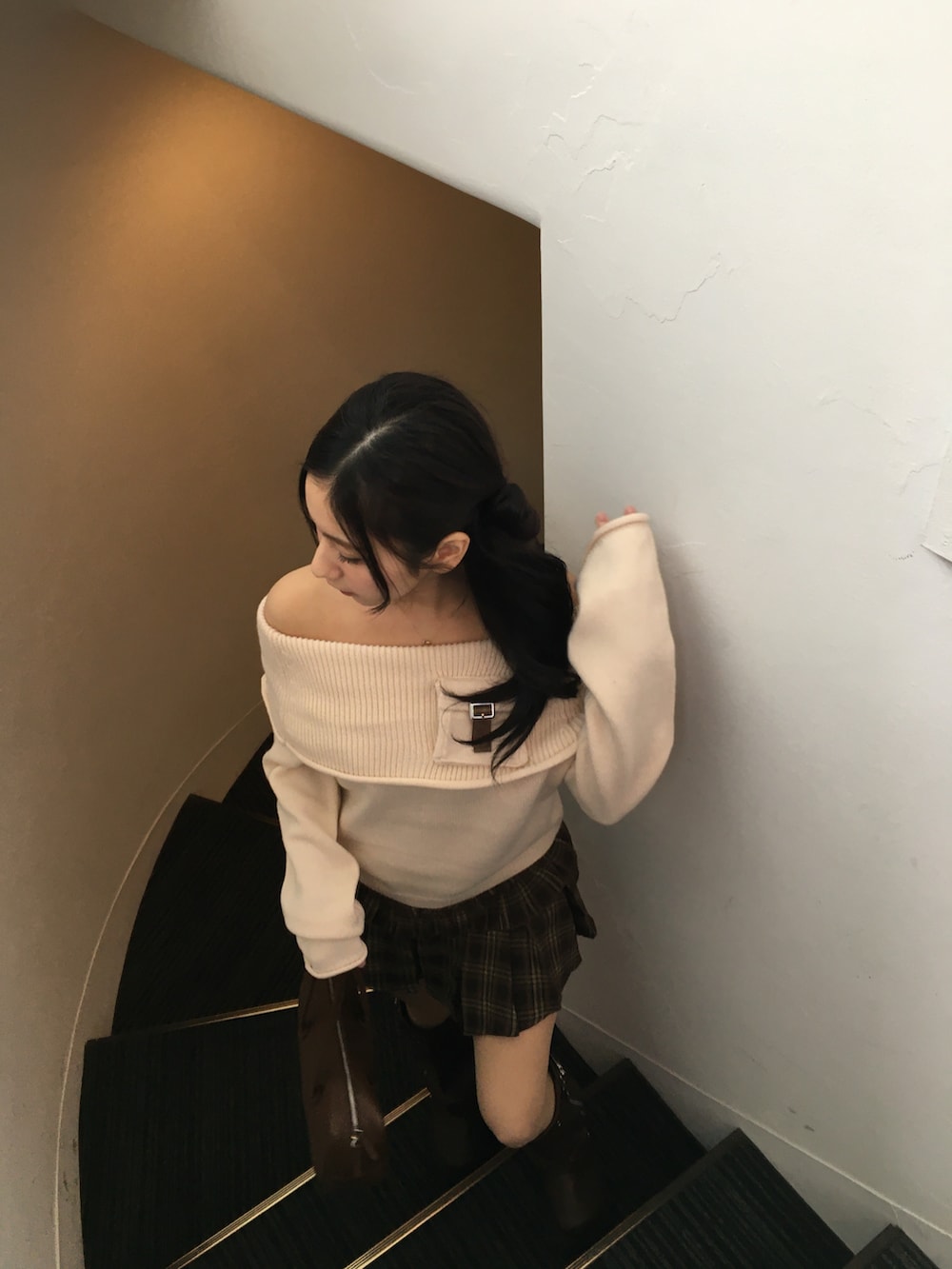 ブラウン系のブーツ、ブラウン系のスカート、ホワイト系のニット/セーターを着用したレディースの冬コーディネートの3枚目の写真