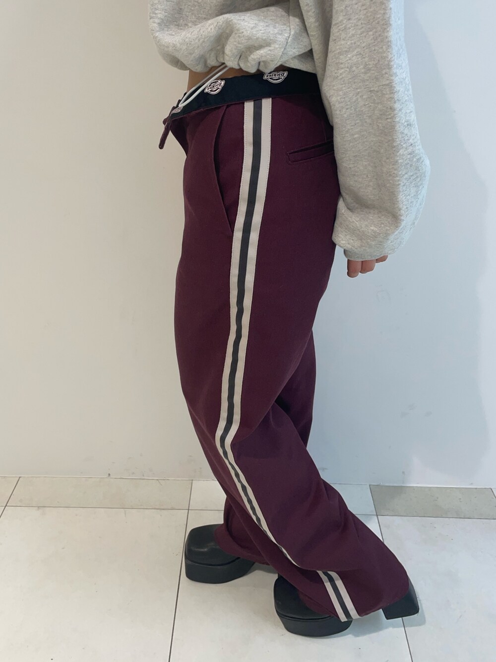 グレー系のスウェット、レッド系のその他パンツ、ブラック系のブーツを着用したレディースの秋コーディネートの4枚目の写真