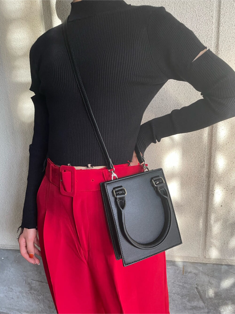ブラック系のハンドバッグ、ブラック系のニット/セーター、レッド系のその他パンツを着用したレディースの秋コーディネートの7枚目の写真