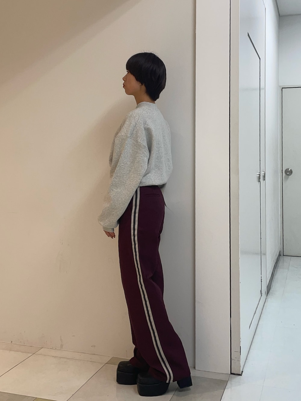 グレー系のスウェット、レッド系のその他パンツ、ブラック系のブーツを着用したレディースの秋コーディネートの2枚目の写真