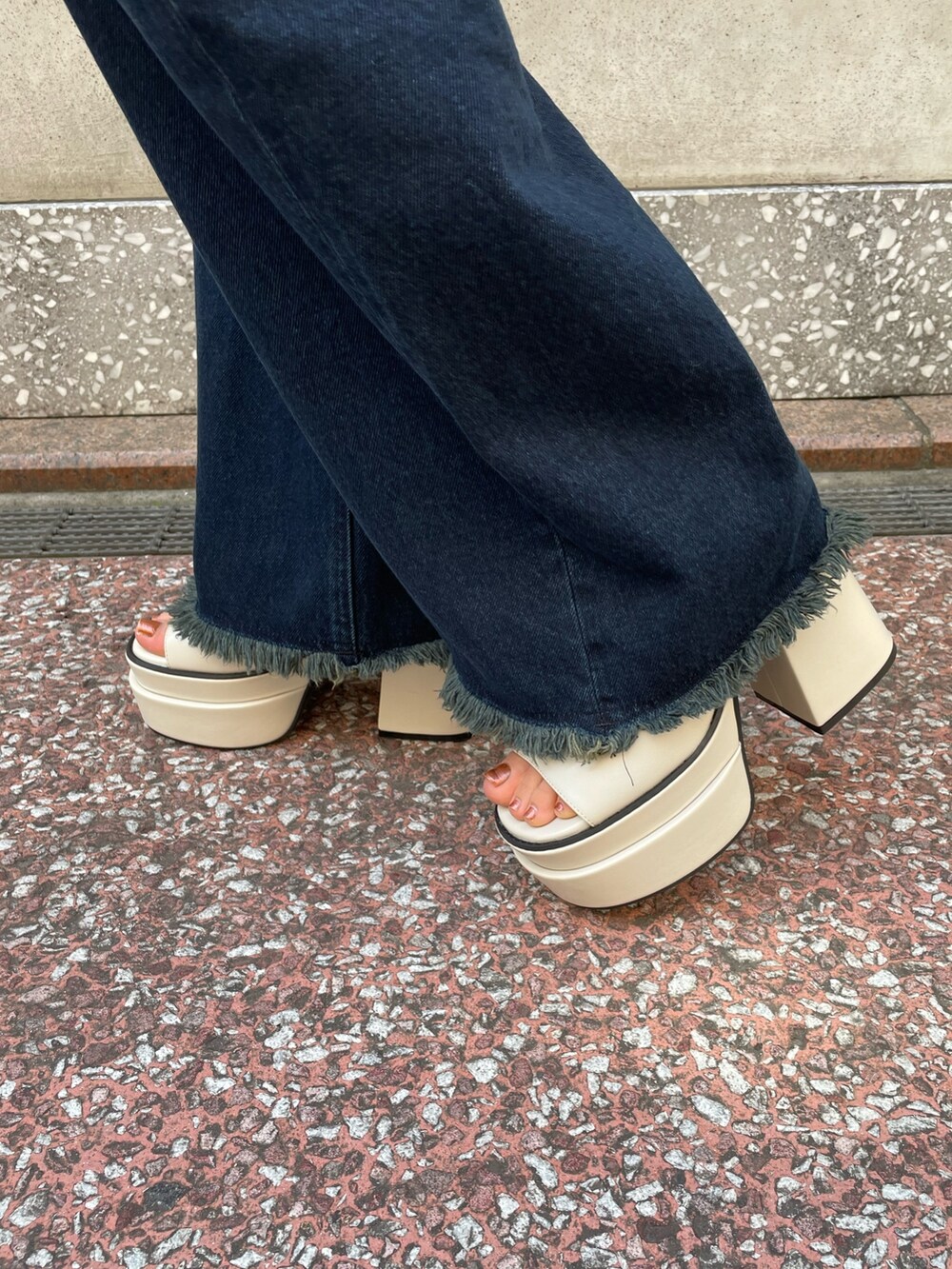 グリーン系のアンサンブル、ブルー系のデニムパンツ、ホワイト系のサンダルを着用したレディースの春コーディネートの7枚目の写真