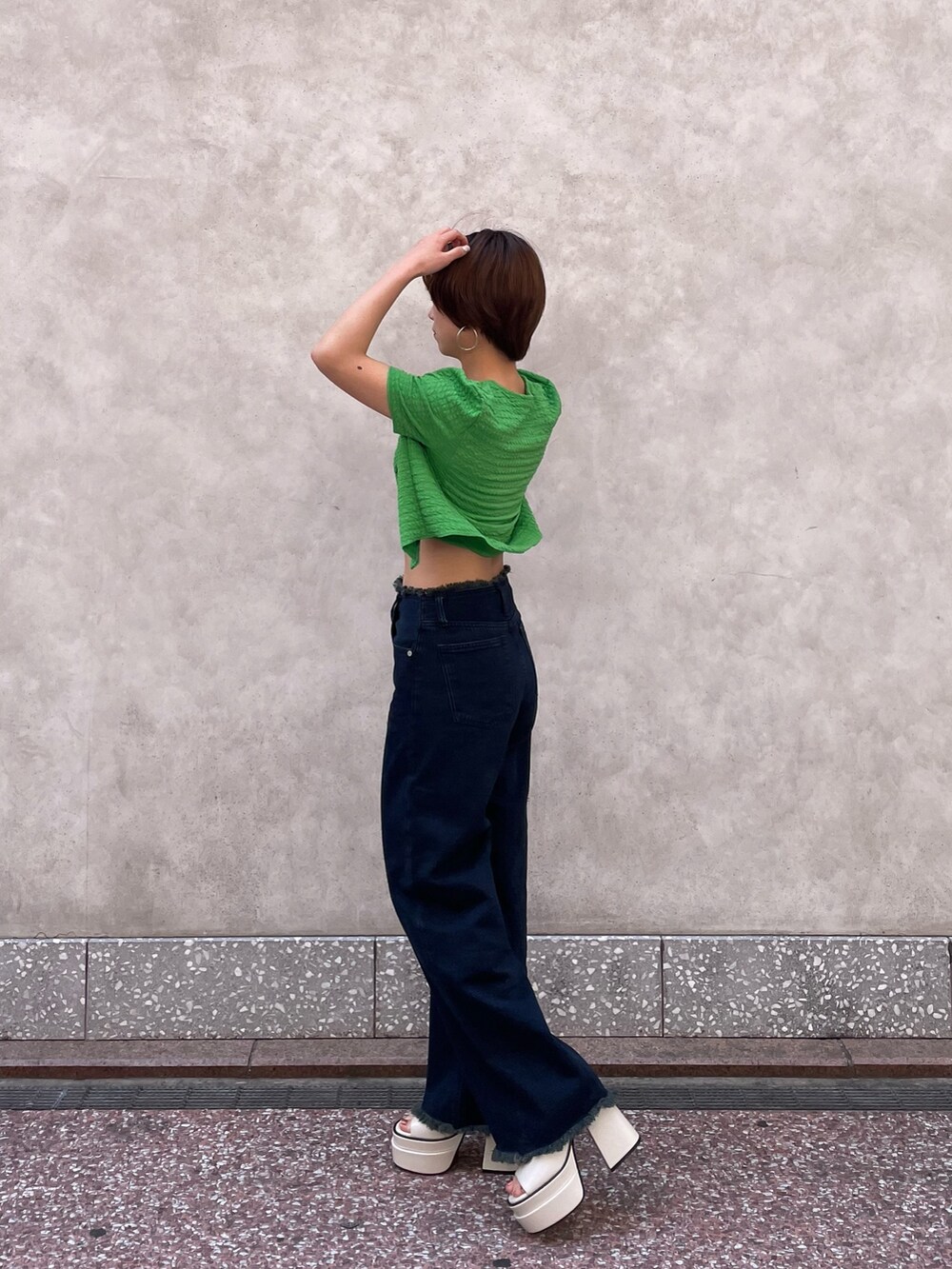 グリーン系のアンサンブル、ブルー系のデニムパンツ、ホワイト系のサンダルを着用したレディースの春コーディネートの3枚目の写真