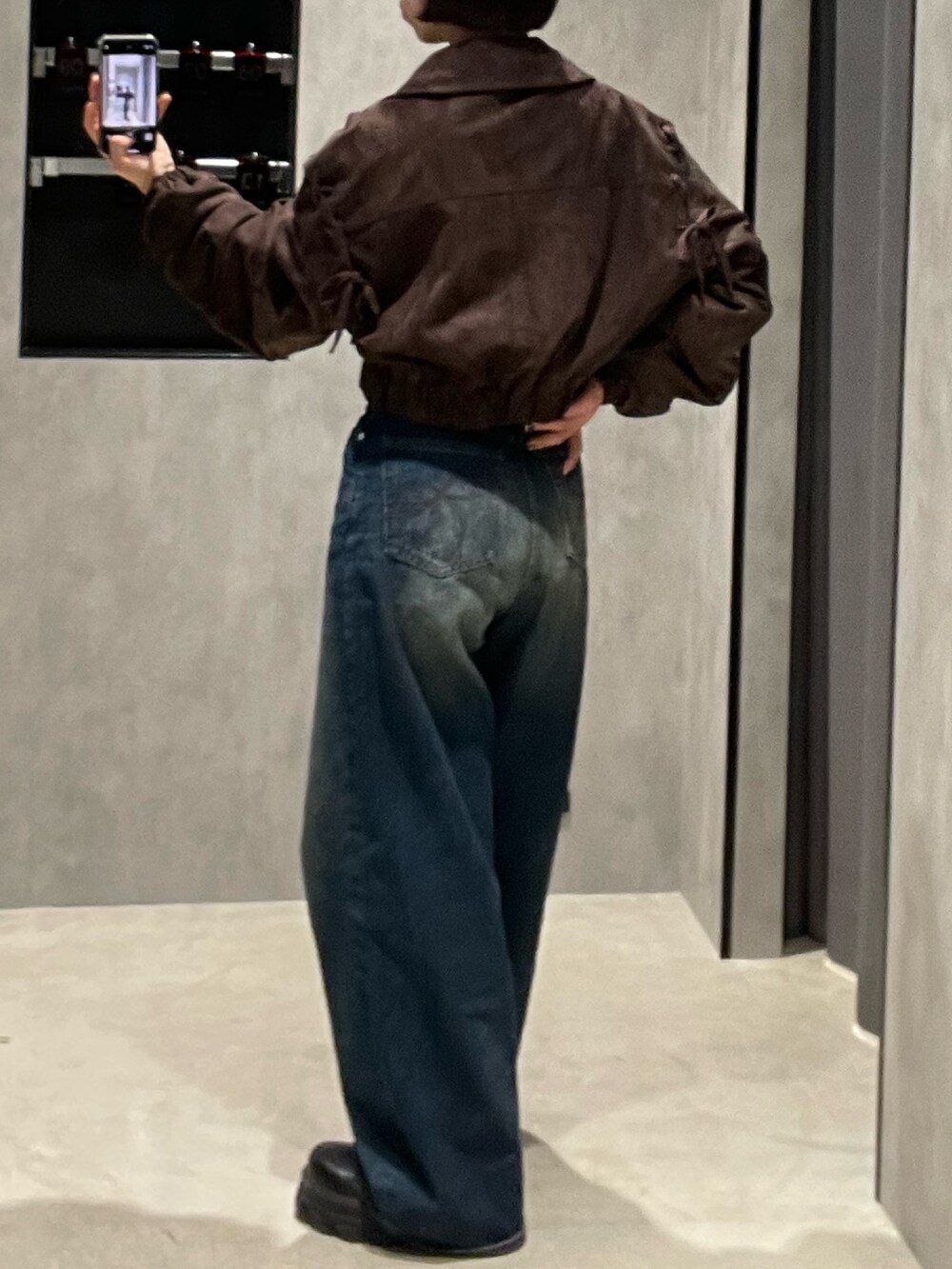 ブラック系のTシャツ/カットソー、ブラウン系のブルゾン、ブルー系のデニムパンツを着用したレディースの秋コーディネートの6枚目の写真