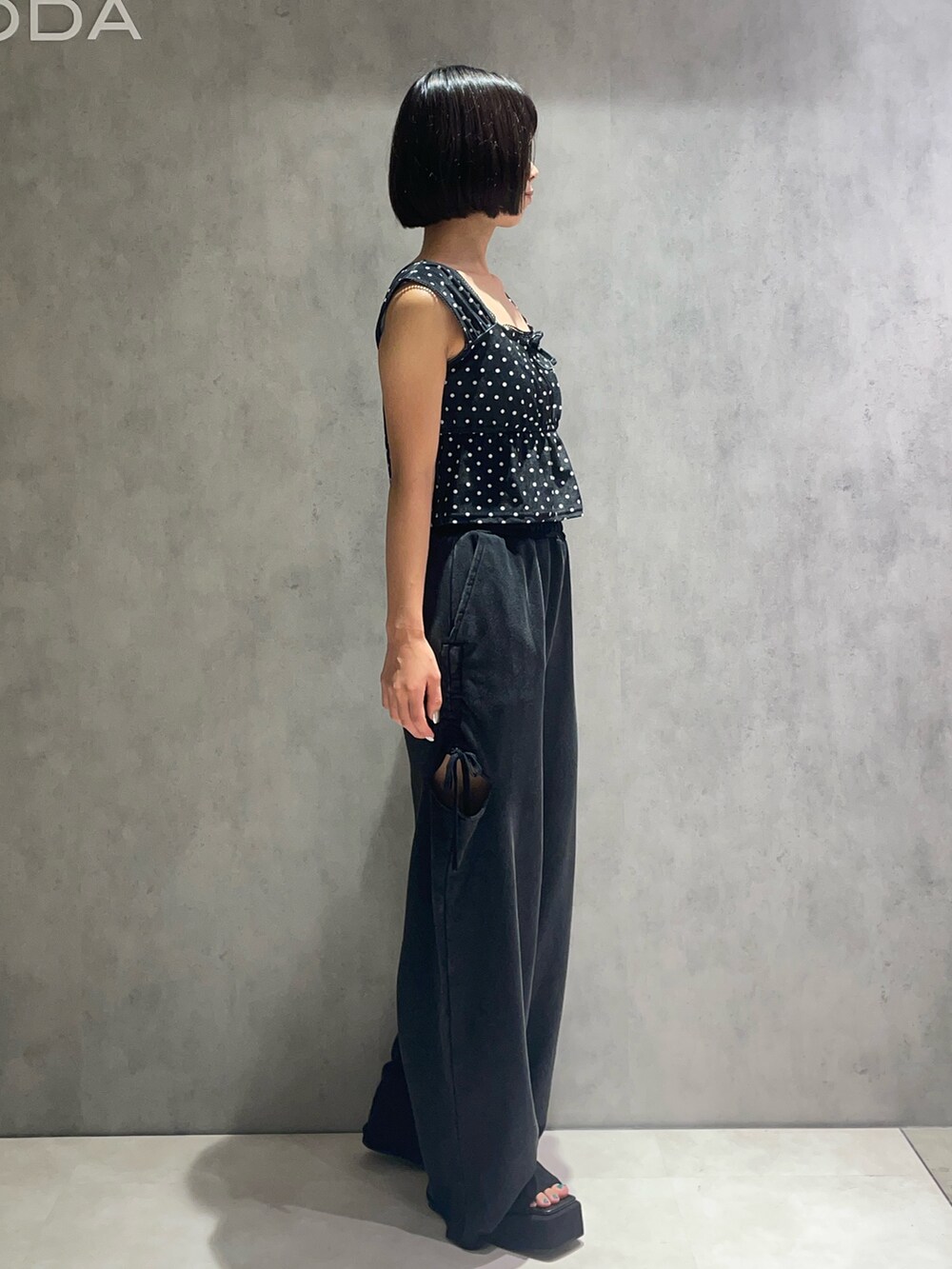 ブラック系のタンクトップ、ブラック系のスウェットパンツ、ブラック系のサンダルを着用したレディースの夏コーディネートの2枚目の写真