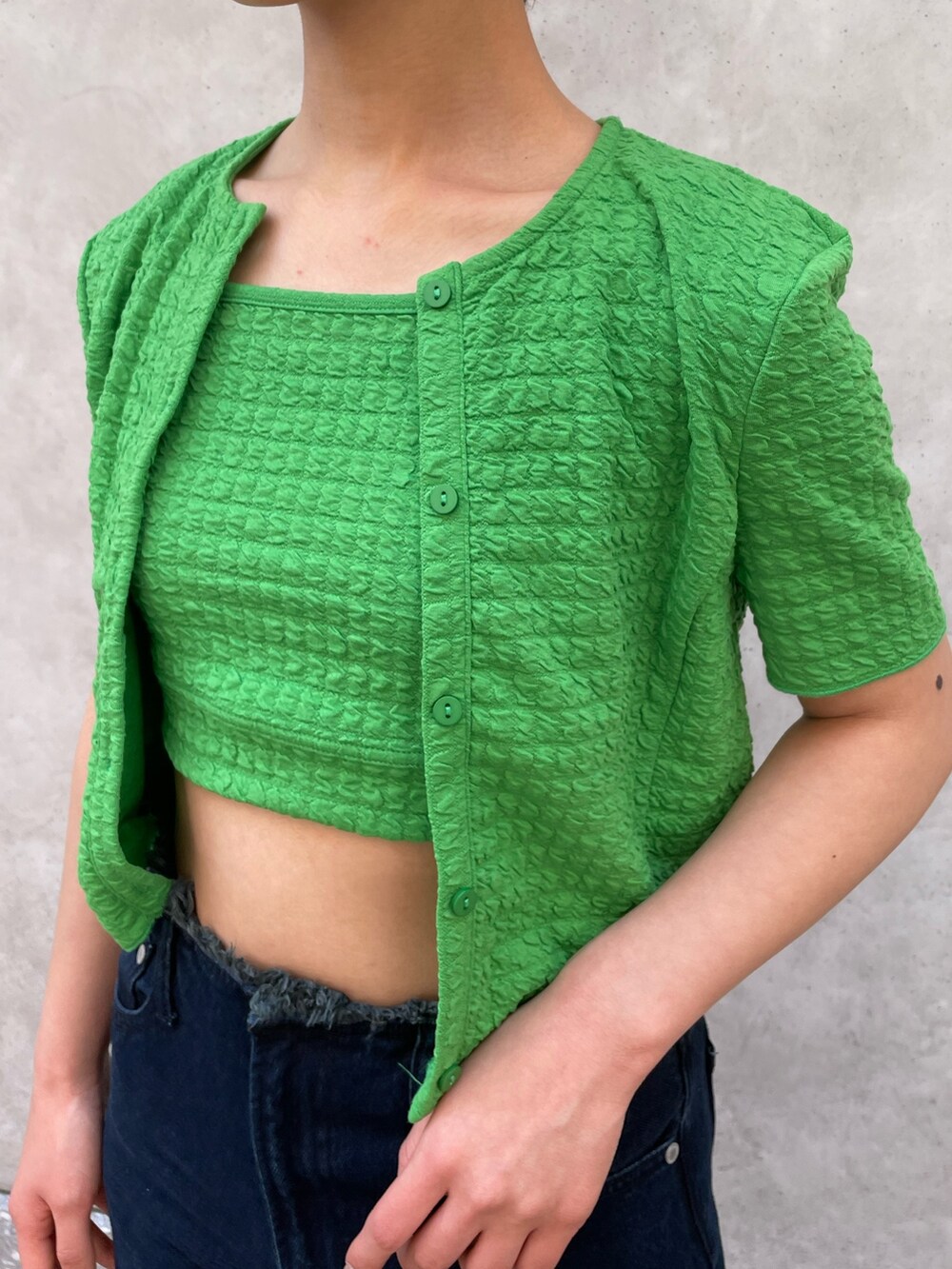 グリーン系のアンサンブル、ブルー系のデニムパンツ、ホワイト系のサンダルを着用したレディースの春コーディネートの5枚目の写真