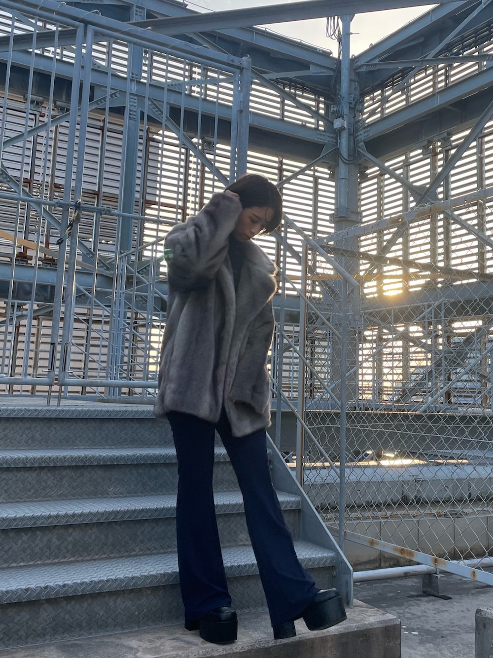 グレー系のその他アウター、ブラック系のニット/セーター、ブルー系のその他パンツを着用したレディースの冬コーディネートの2枚目の写真