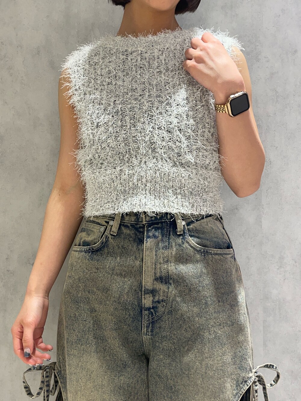 ホワイト系のニット/セーター、ブルー系のデニムパンツ、ブラック系のサンダルを着用したレディースの春コーディネートの6枚目の写真