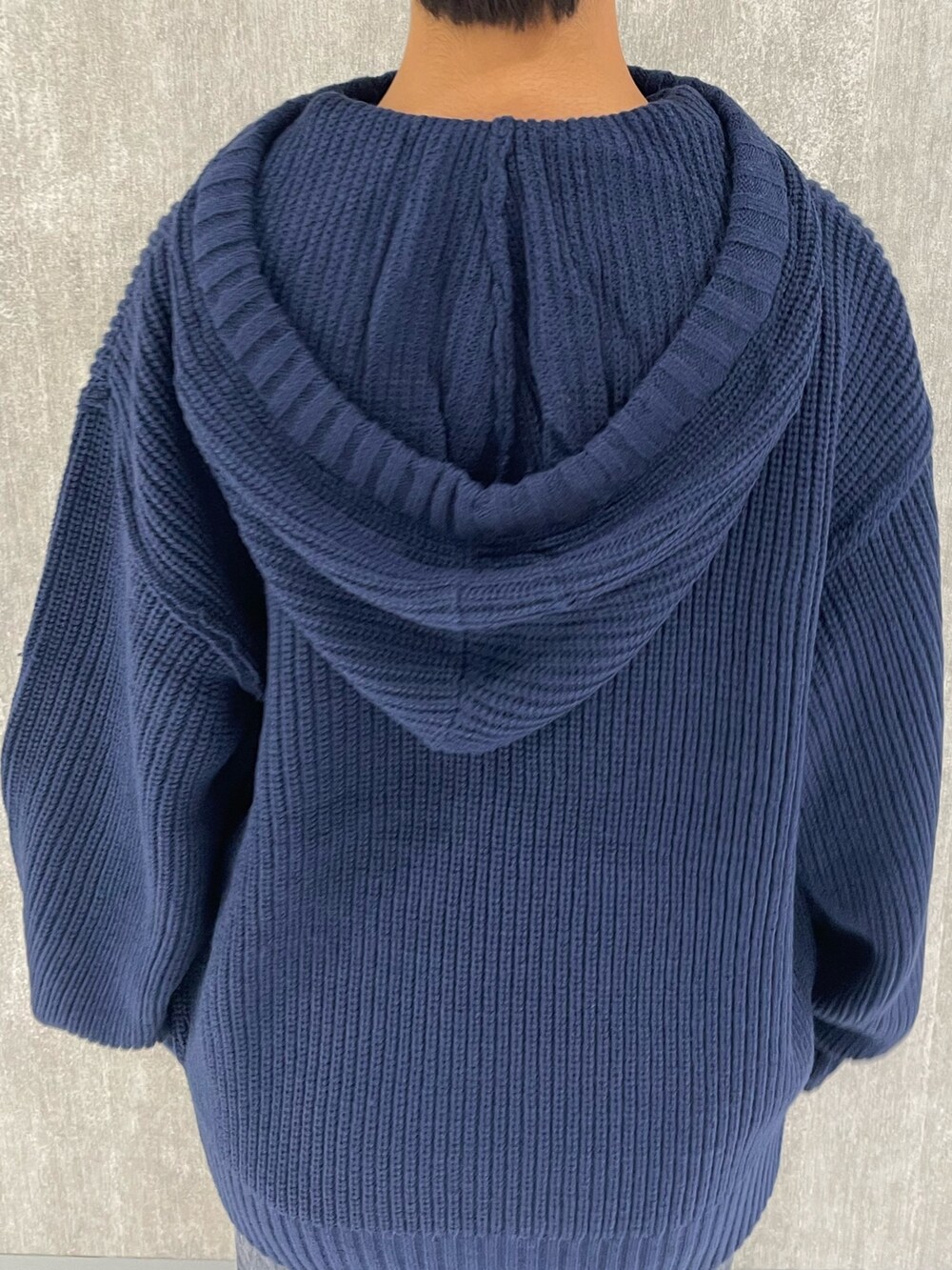 ブルー系のニット/セーター、ブラック系のブーツ、グレー系のスカートを着用したレディースの秋コーディネートの4枚目の写真