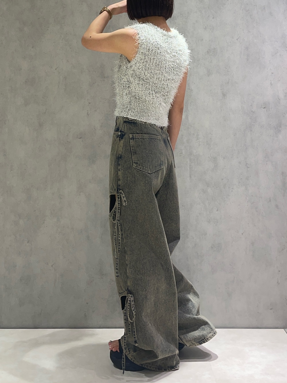 ホワイト系のニット/セーター、ブルー系のデニムパンツ、ブラック系のサンダルを着用したレディースの春コーディネートの2枚目の写真