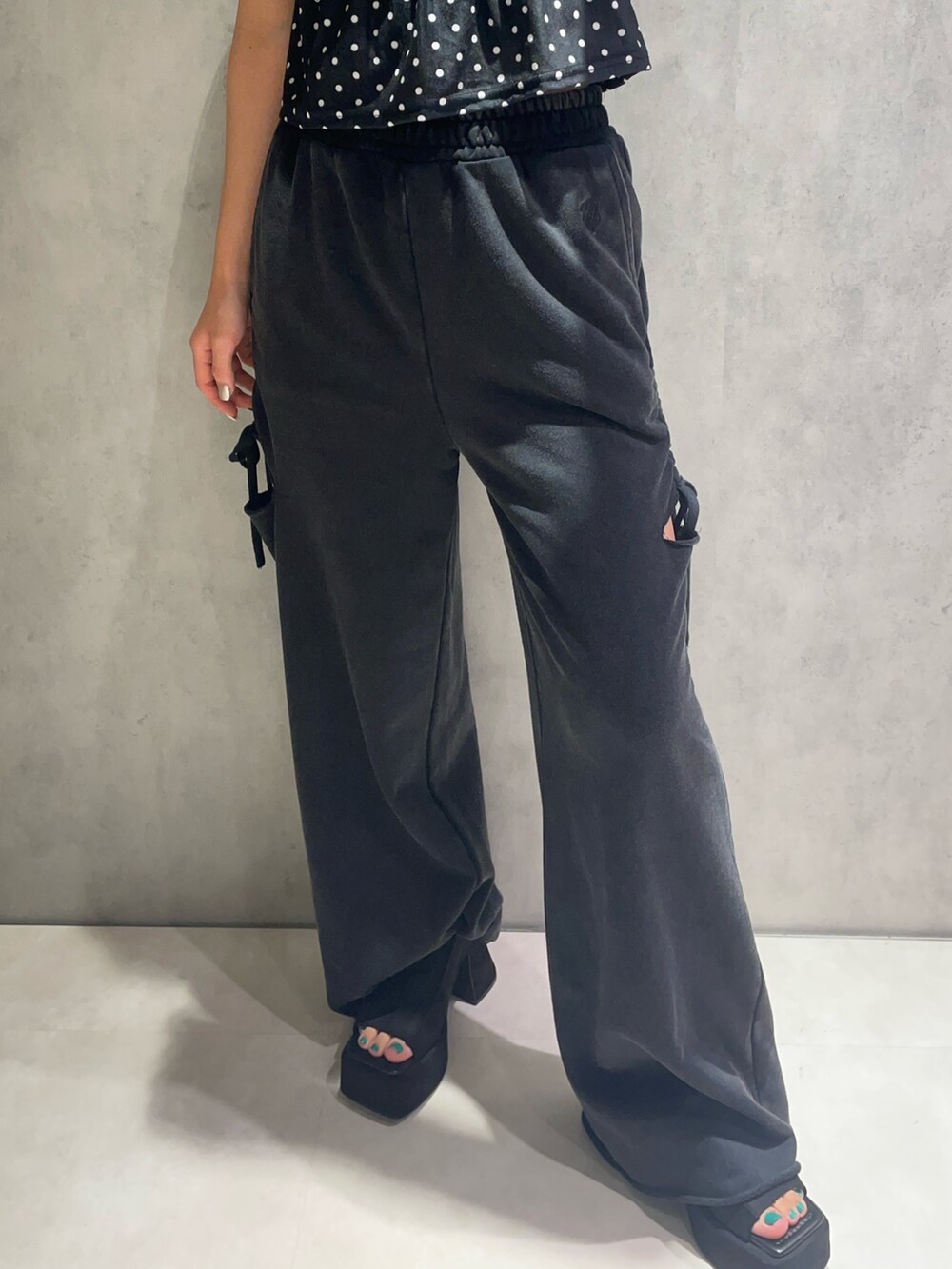 ブラック系のタンクトップ、ブラック系のスウェットパンツ、ブラック系のサンダルを着用したレディースの夏コーディネートの6枚目の写真