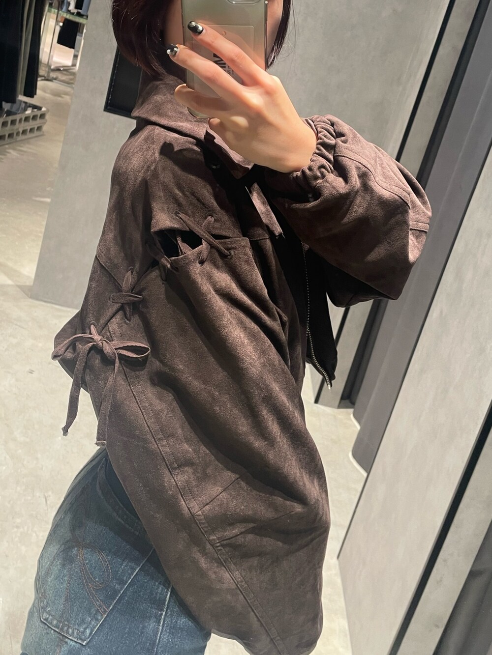 ブラック系のTシャツ/カットソー、ブラウン系のブルゾン、ブルー系のデニムパンツを着用したレディースの秋コーディネートの3枚目の写真