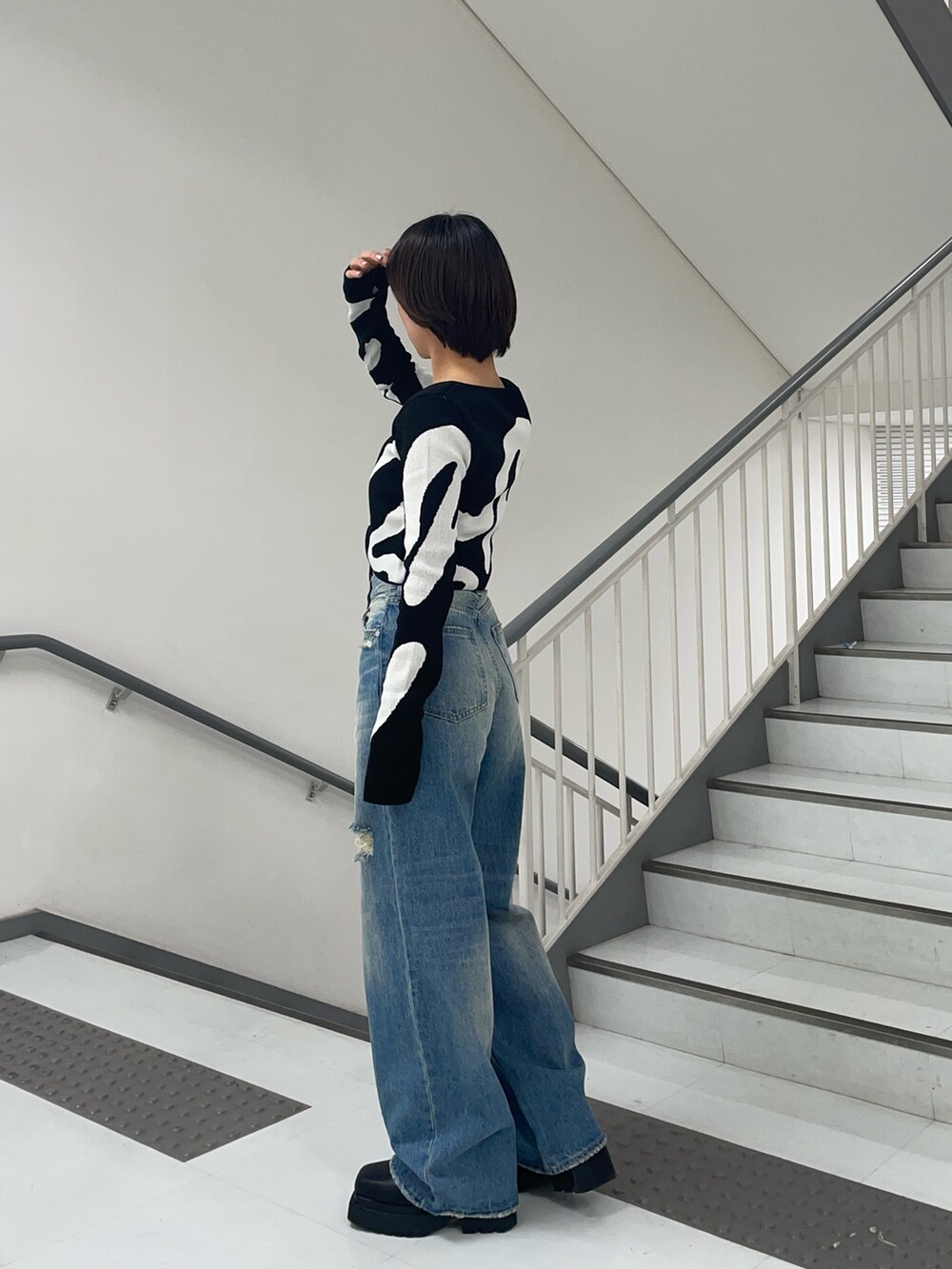 その他のニット/セーター、ブルー系のデニムパンツ、ブラック系のブーツを着用したレディースの春コーディネートの2枚目の写真