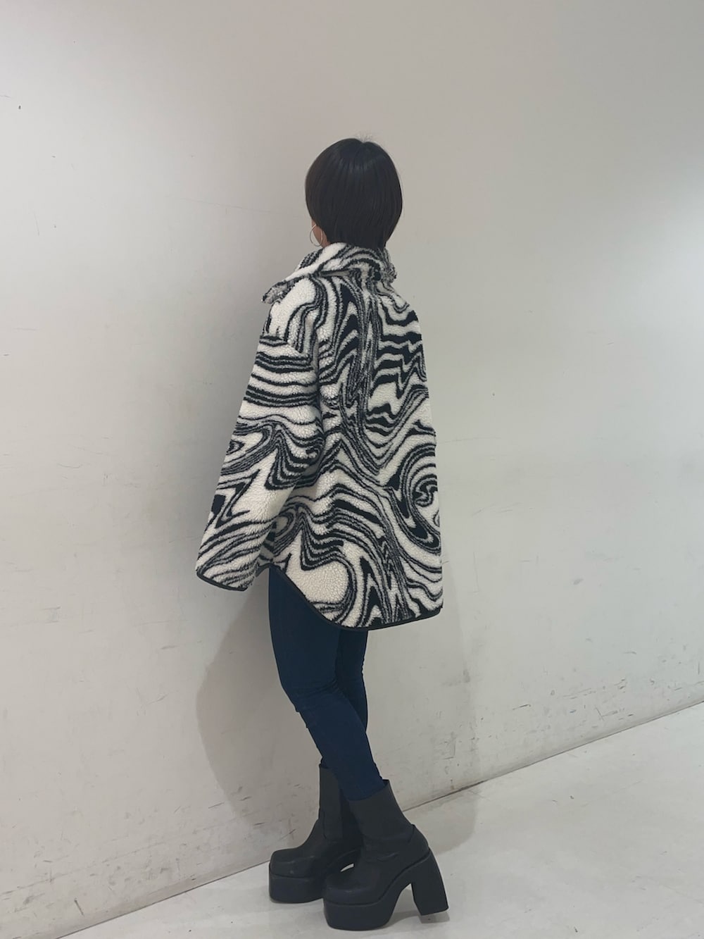 ブラック系のTシャツ/カットソー、ブルー系のデニムパンツ、ブラック系のブーツを着用したレディースの秋コーディネートの2枚目の写真