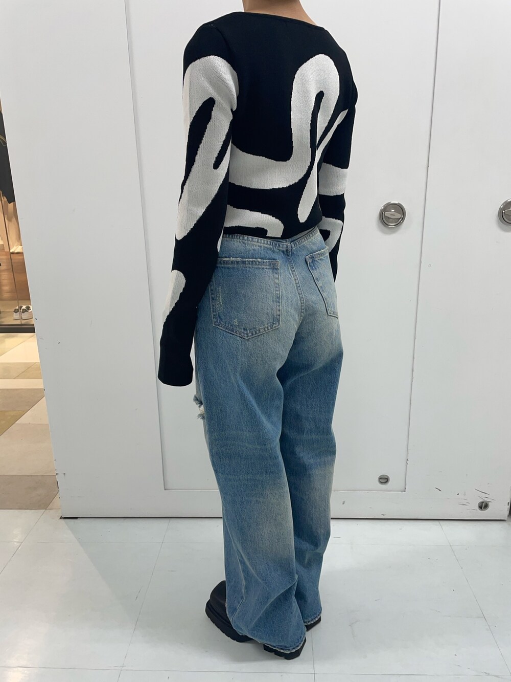 その他のニット/セーター、ブルー系のデニムパンツ、ブラック系のブーツを着用したレディースの春コーディネートの6枚目の写真