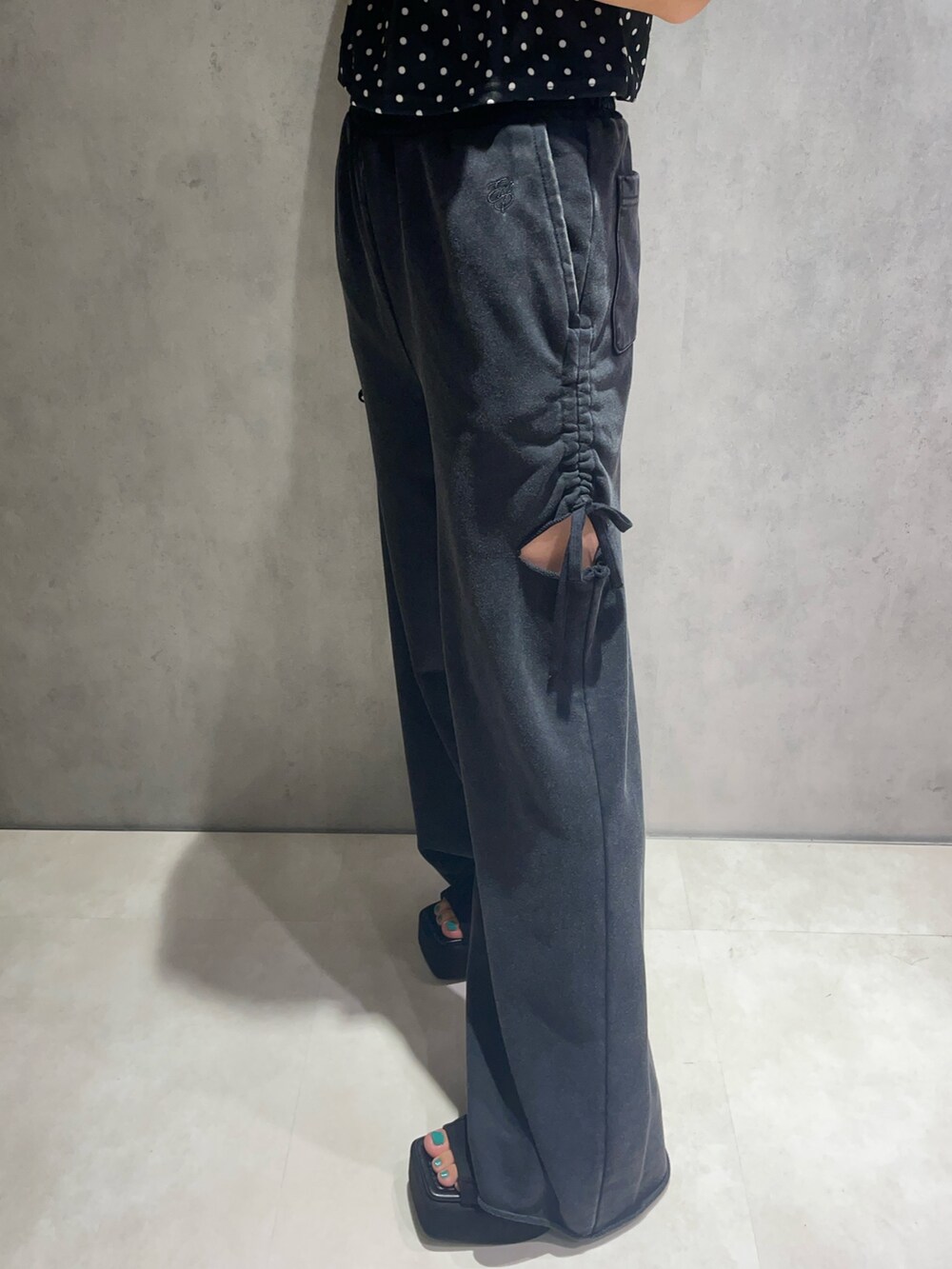 ブラック系のタンクトップ、ブラック系のスウェットパンツ、ブラック系のサンダルを着用したレディースの夏コーディネートの7枚目の写真