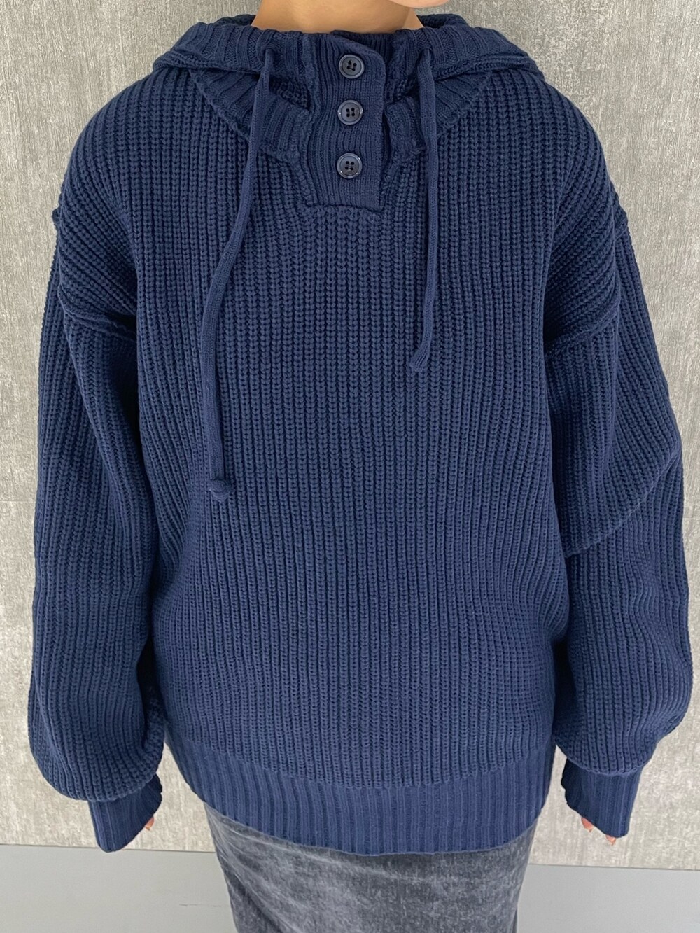 ブルー系のニット/セーター、ブラック系のブーツ、グレー系のスカートを着用したレディースの秋コーディネートの3枚目の写真