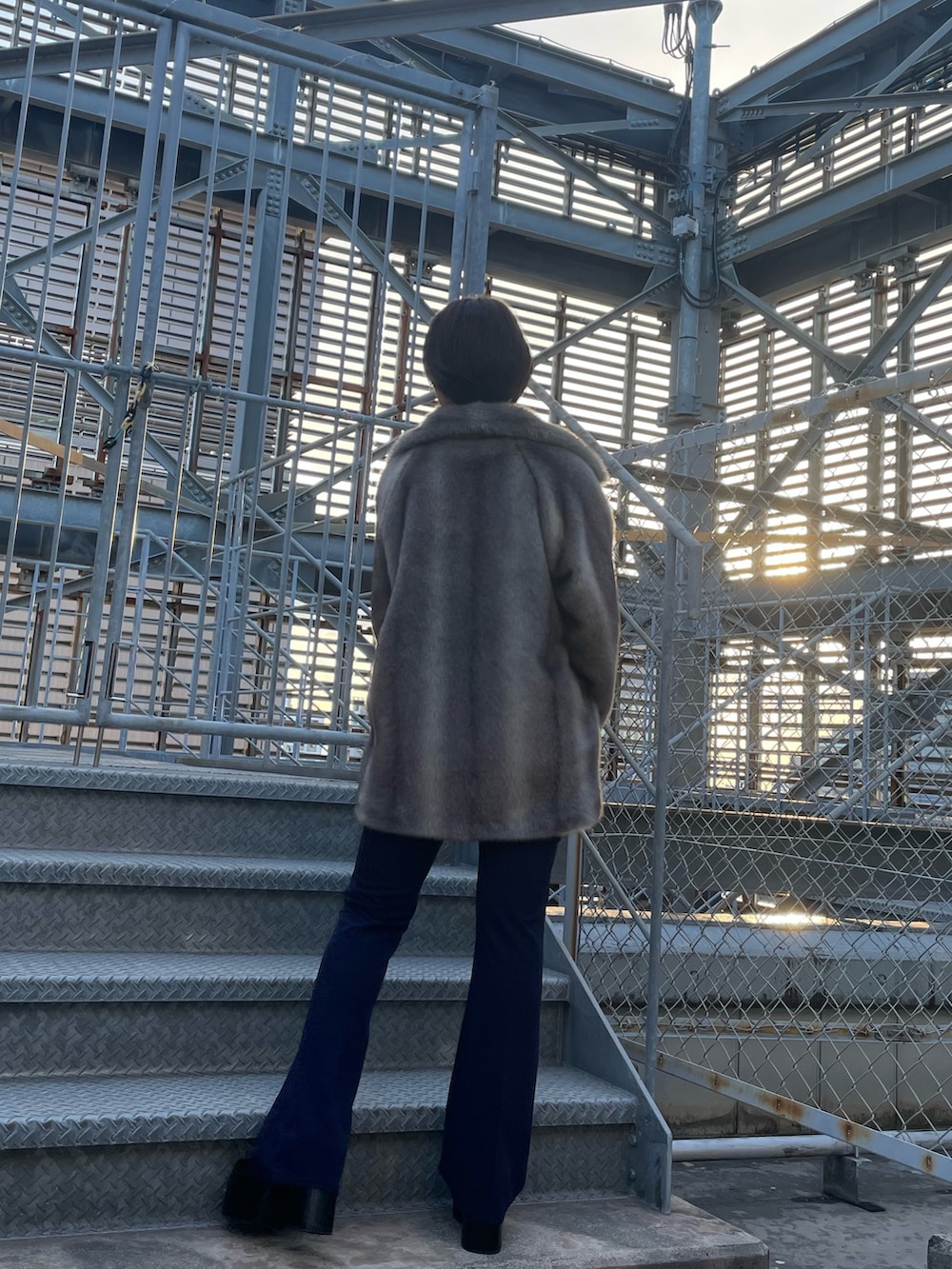 グレー系のその他アウター、ブラック系のニット/セーター、ブルー系のその他パンツを着用したレディースの冬コーディネートの3枚目の写真