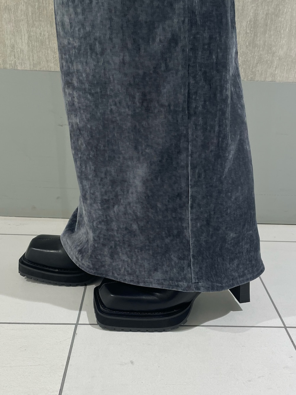 ブルー系のニット/セーター、ブラック系のブーツ、グレー系のスカートを着用したレディースの秋コーディネートの7枚目の写真