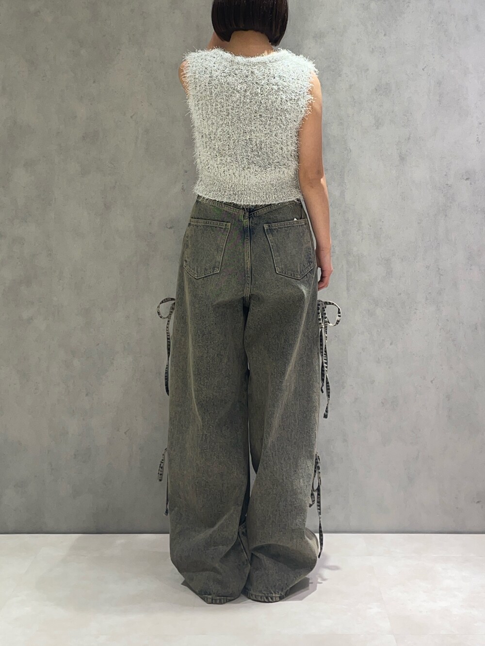 ホワイト系のニット/セーター、ブルー系のデニムパンツ、ブラック系のサンダルを着用したレディースの春コーディネートの3枚目の写真