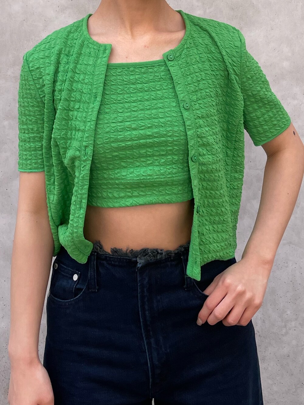 グリーン系のアンサンブル、ブルー系のデニムパンツ、ホワイト系のサンダルを着用したレディースの春コーディネートの4枚目の写真