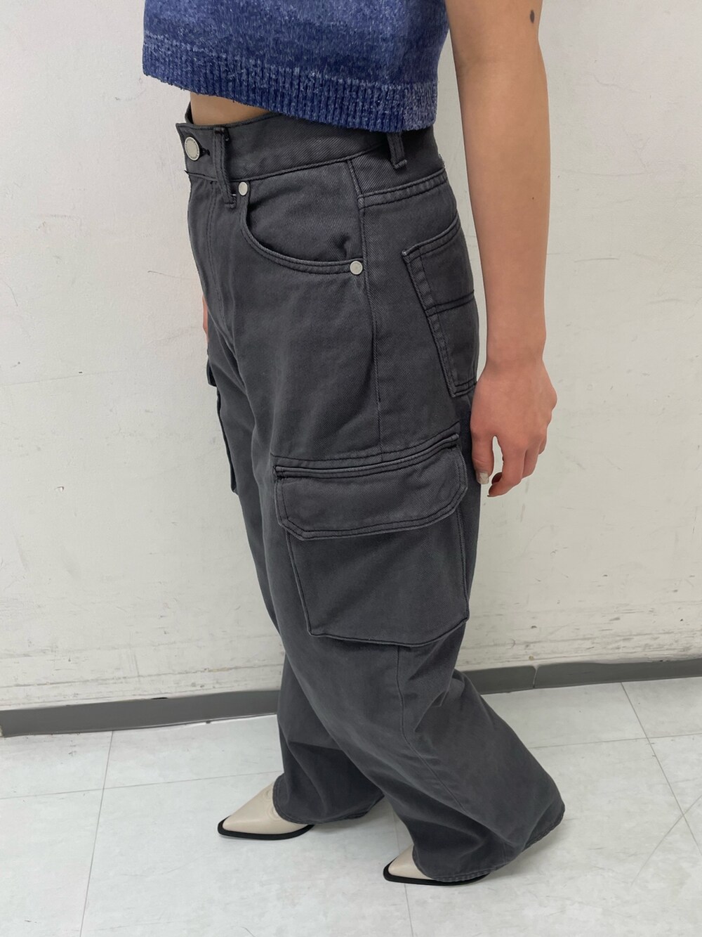 ブルー系のタンクトップ、ブラック系のデニムパンツ、ホワイト系のブーツを着用したレディースの春コーディネートの6枚目の写真