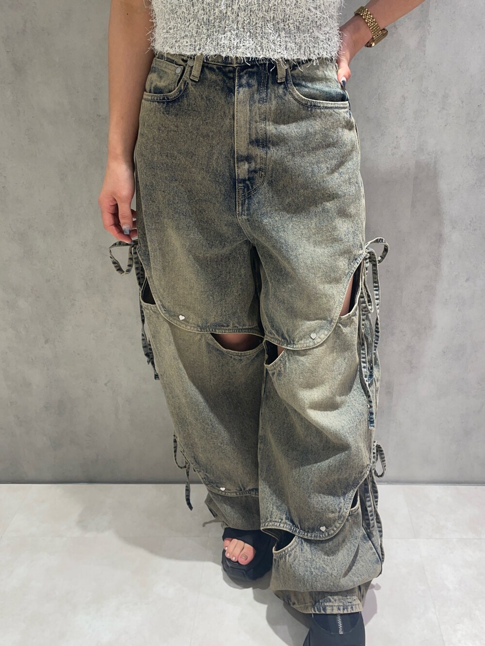 ホワイト系のニット/セーター、ブルー系のデニムパンツ、ブラック系のサンダルを着用したレディースの春コーディネートの4枚目の写真