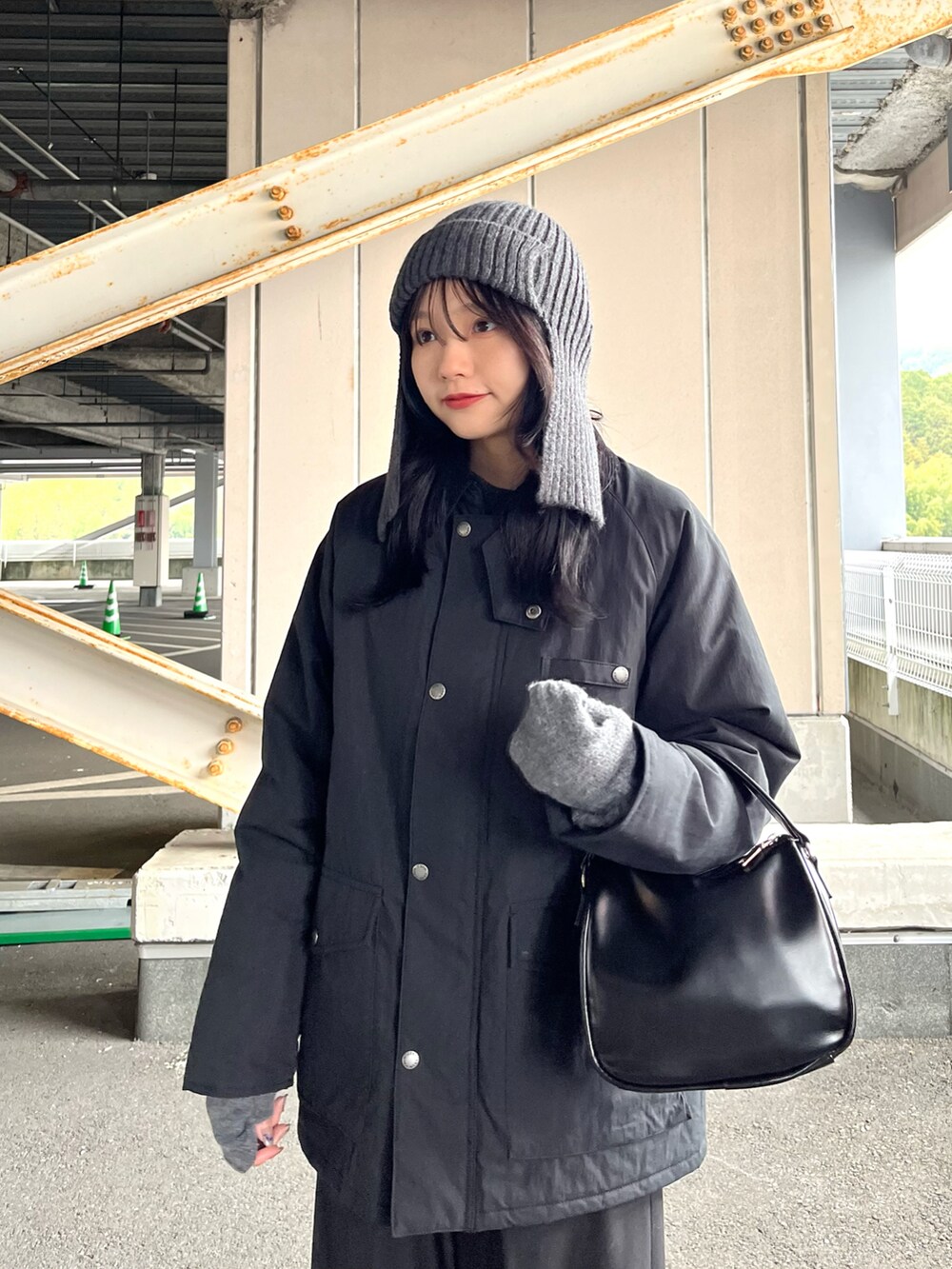 ブラック系のブルゾン、ブラック系のスラックス、ブラック系のショルダーバッグを着用したレディースの冬コーディネートの2枚目の写真