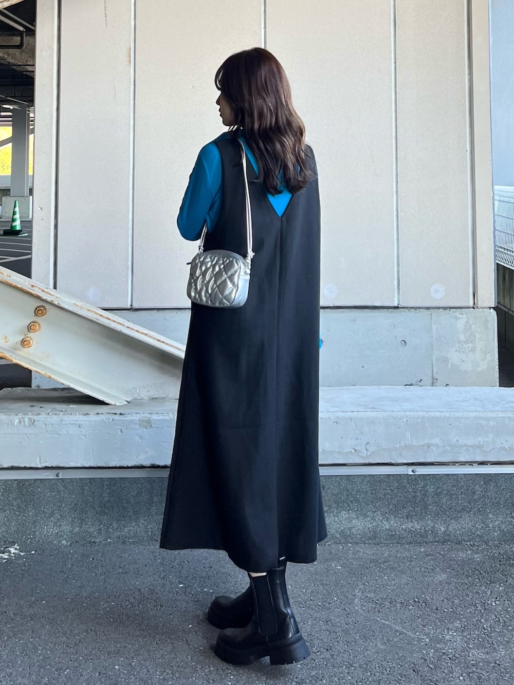 ブラック系のブーツ、ブラック系のジャンパースカート、ブルー系のTシャツ/カットソーを着用したレディースの冬コーディネートの3枚目の写真