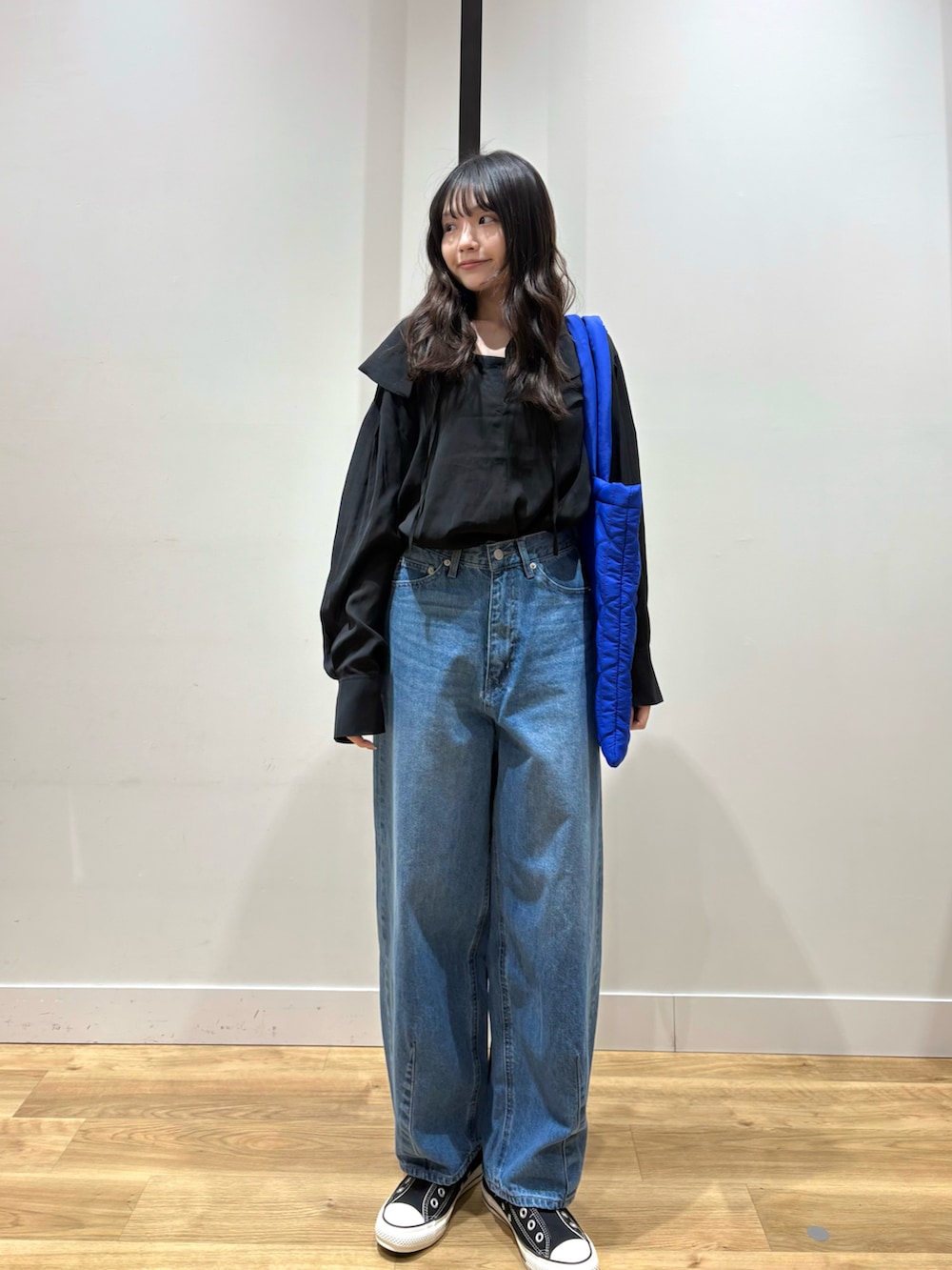 ブラック系のシャツ/ブラウス、ブルー系のデニムパンツ、ブルー系のトートバッグを着用したレディースの春コーディネートの2枚目の写真