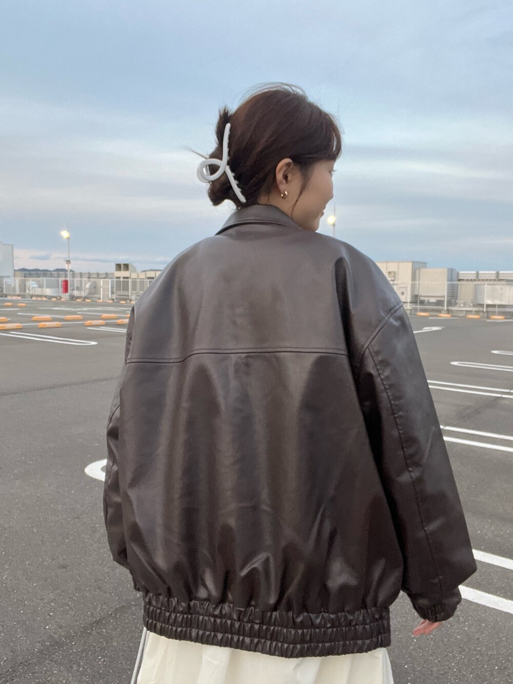 ピンク系のニット/セーター、ブラウン系のブルゾン、ホワイト系のスカートを着用したレディースの冬コーディネートの6枚目の写真