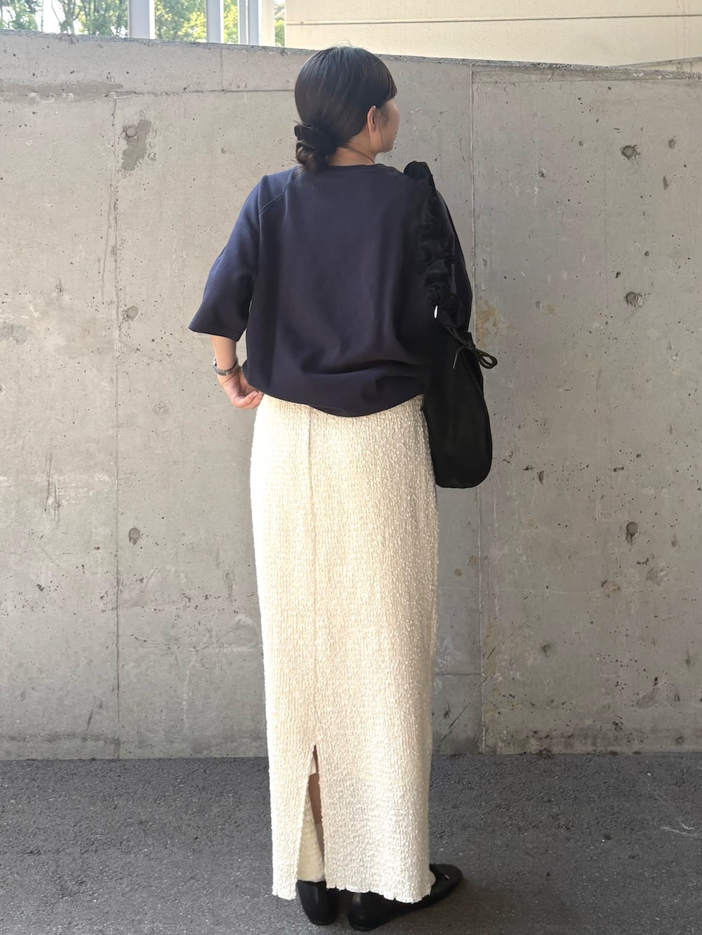 ブルー系のTシャツ/カットソー、ホワイト系のスカート、ブラック系のショルダーバッグを着用したレディースの秋コーディネートの2枚目の写真