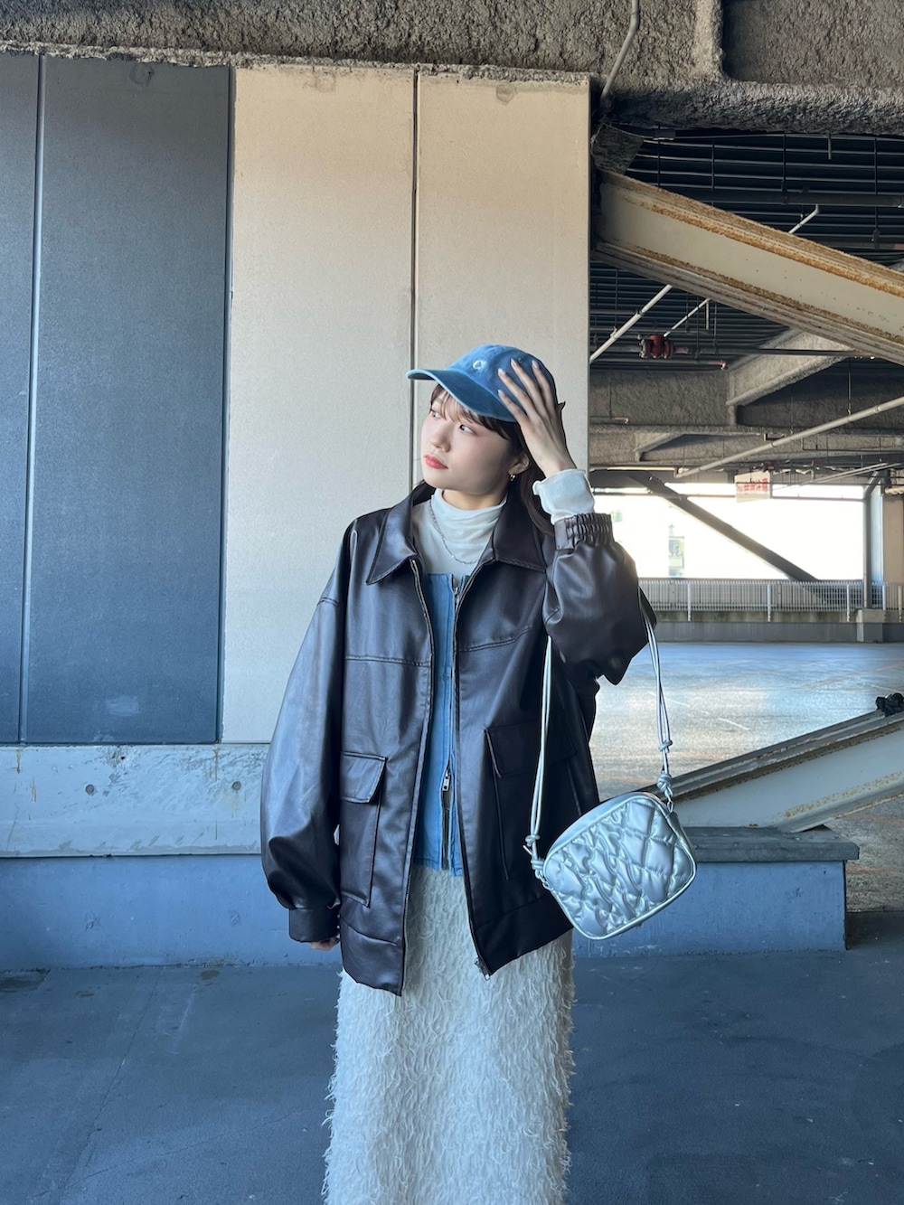 ブラウン系のブルゾン、ホワイト系のTシャツ/カットソー、ブルー系のシャツ/ブラウスを着用したレディースの冬コーディネートの2枚目の写真